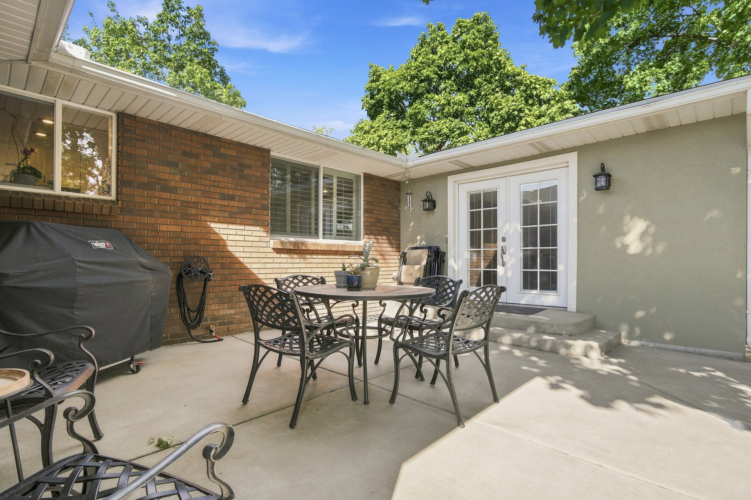 Expansive concrete patio with dual French doors offering exterior access