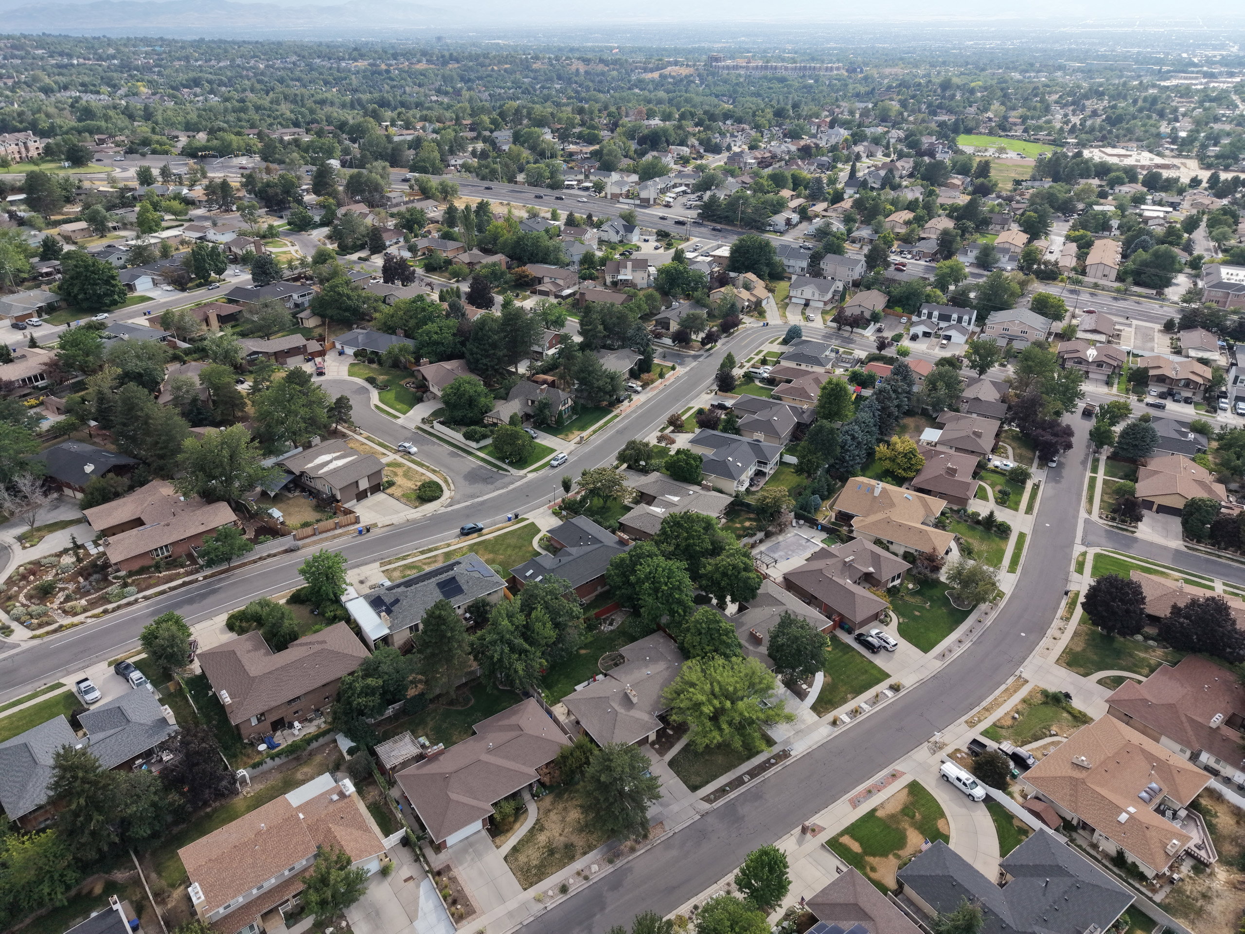 Residential neighborhood featuring mature trees, paved streets, and a variety of architectural styles