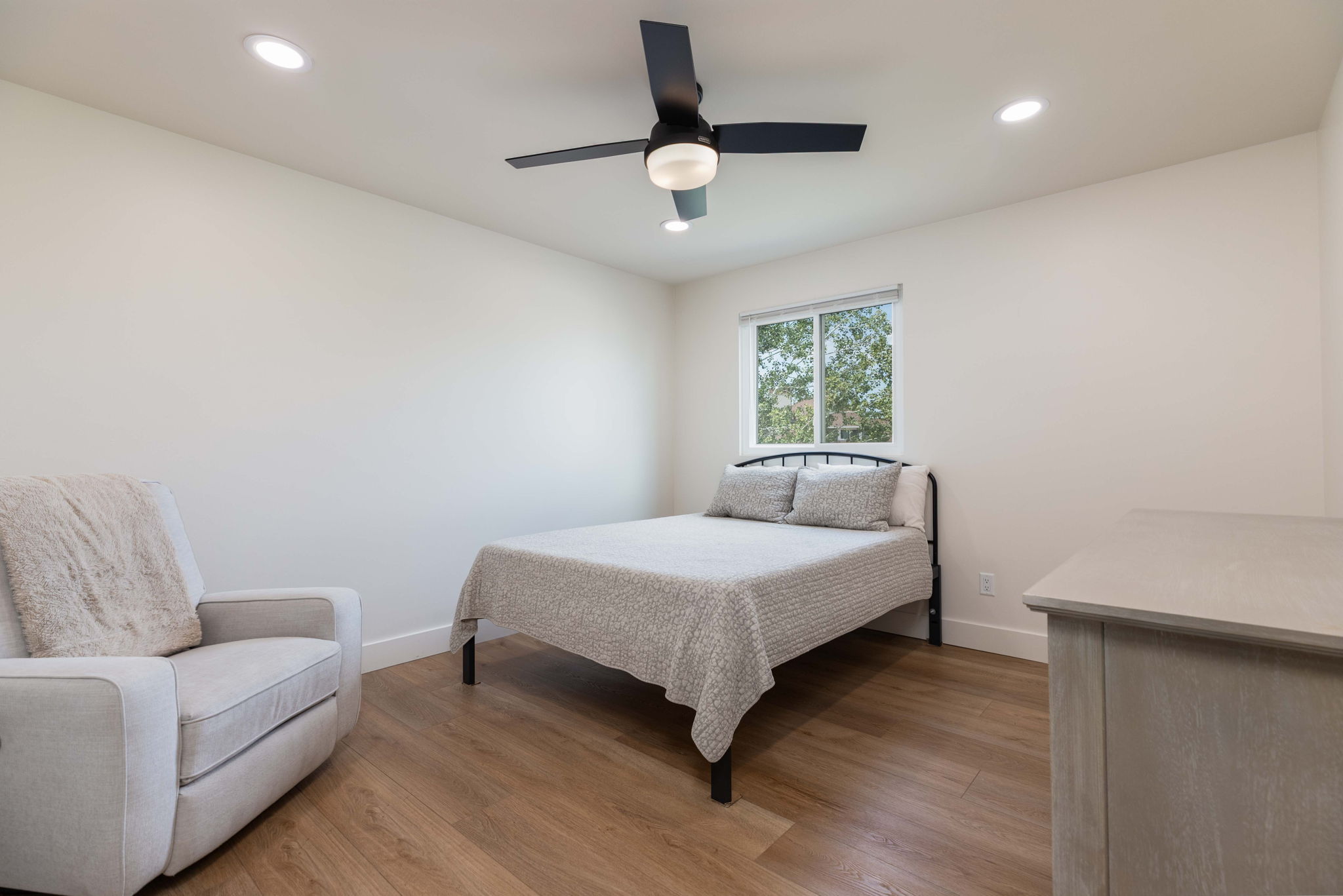Bright room featuring recessed lighting, a modern ceiling fan, a window, and wood-finish flooring