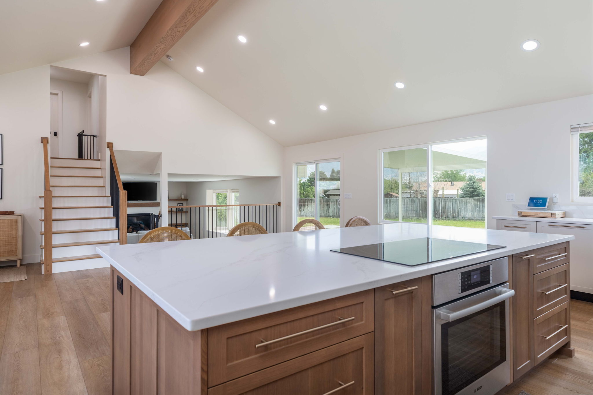 Kitchen island with a light-toned countertop, integrated induction cooktop, and built-in oven