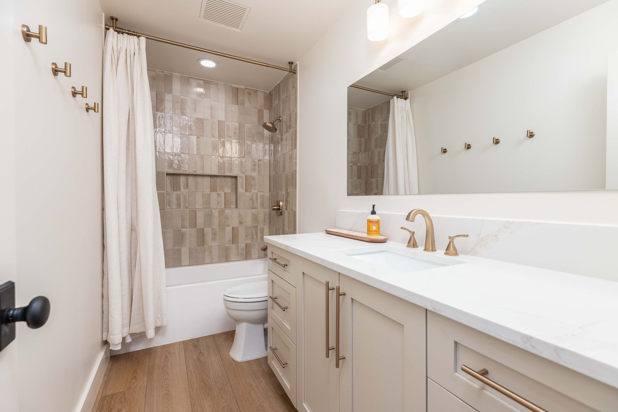 Bathroom with a single vanity, undermount sink, and light-toned cabinetry