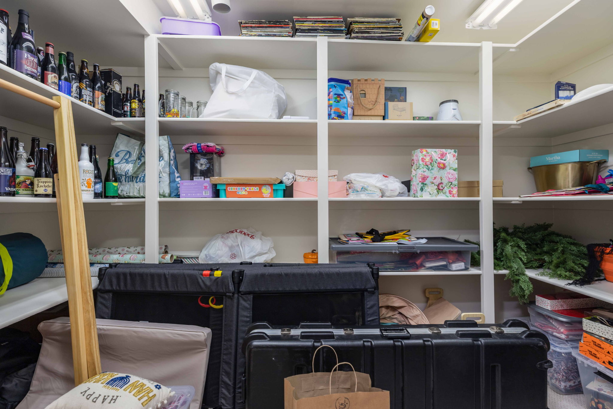 Built-in white shelving system featuring multiple tiers of storage, integrated lighting, and a corner configuration