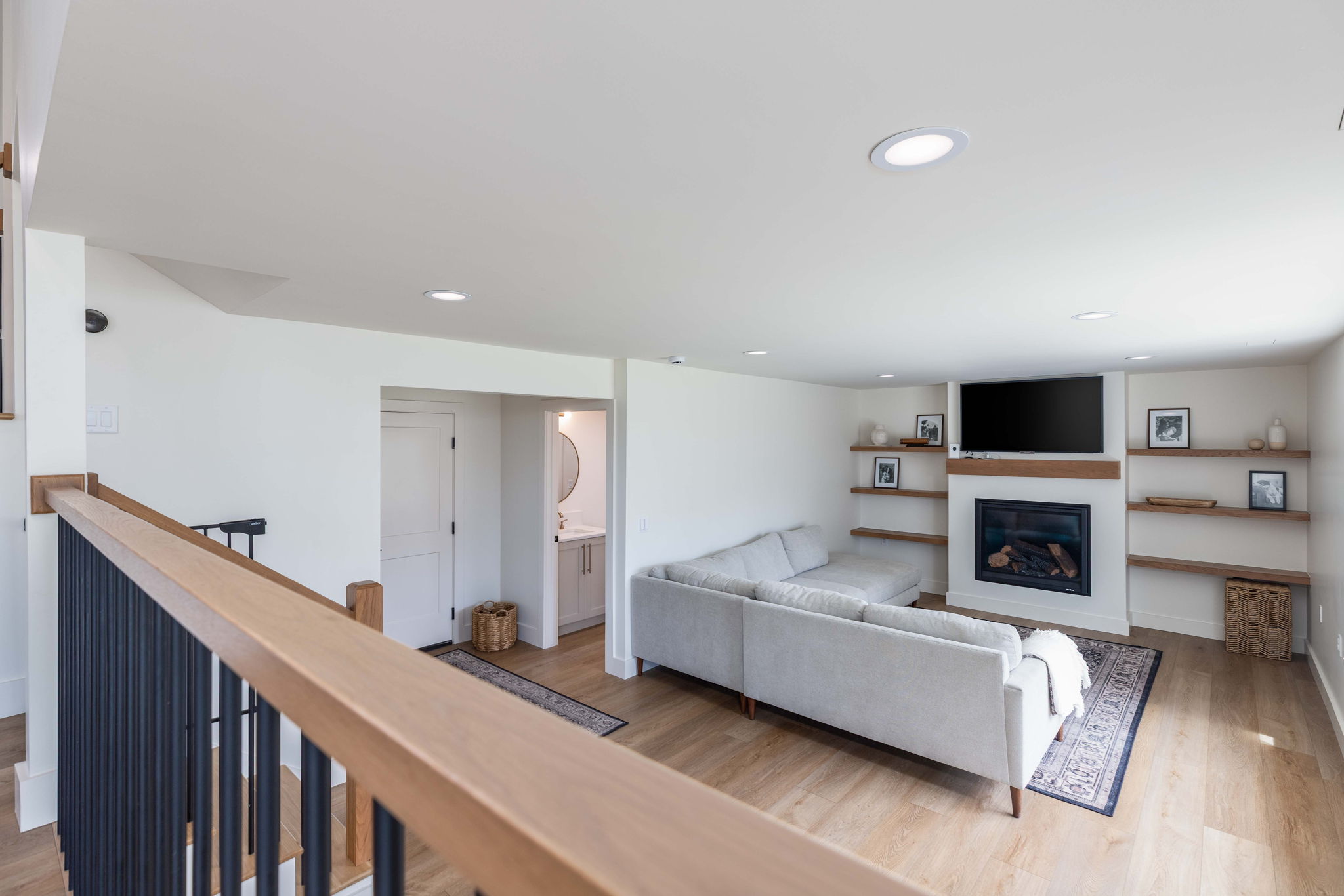 Recreational room featuring a fireplace with a wood mantle and integrated shelving