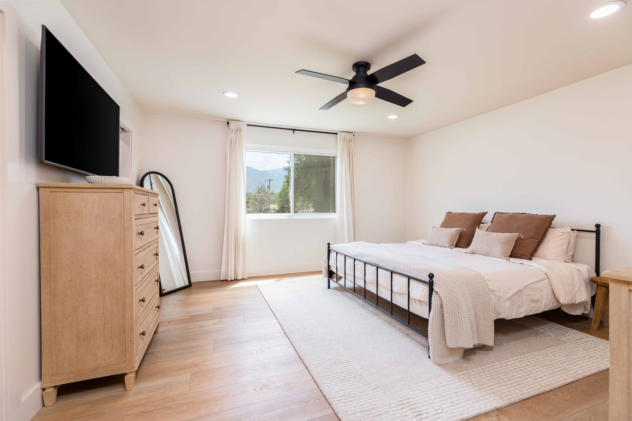 Spacious room featuring wood-finish flooring, recessed lighting, and a contemporary ceiling fan