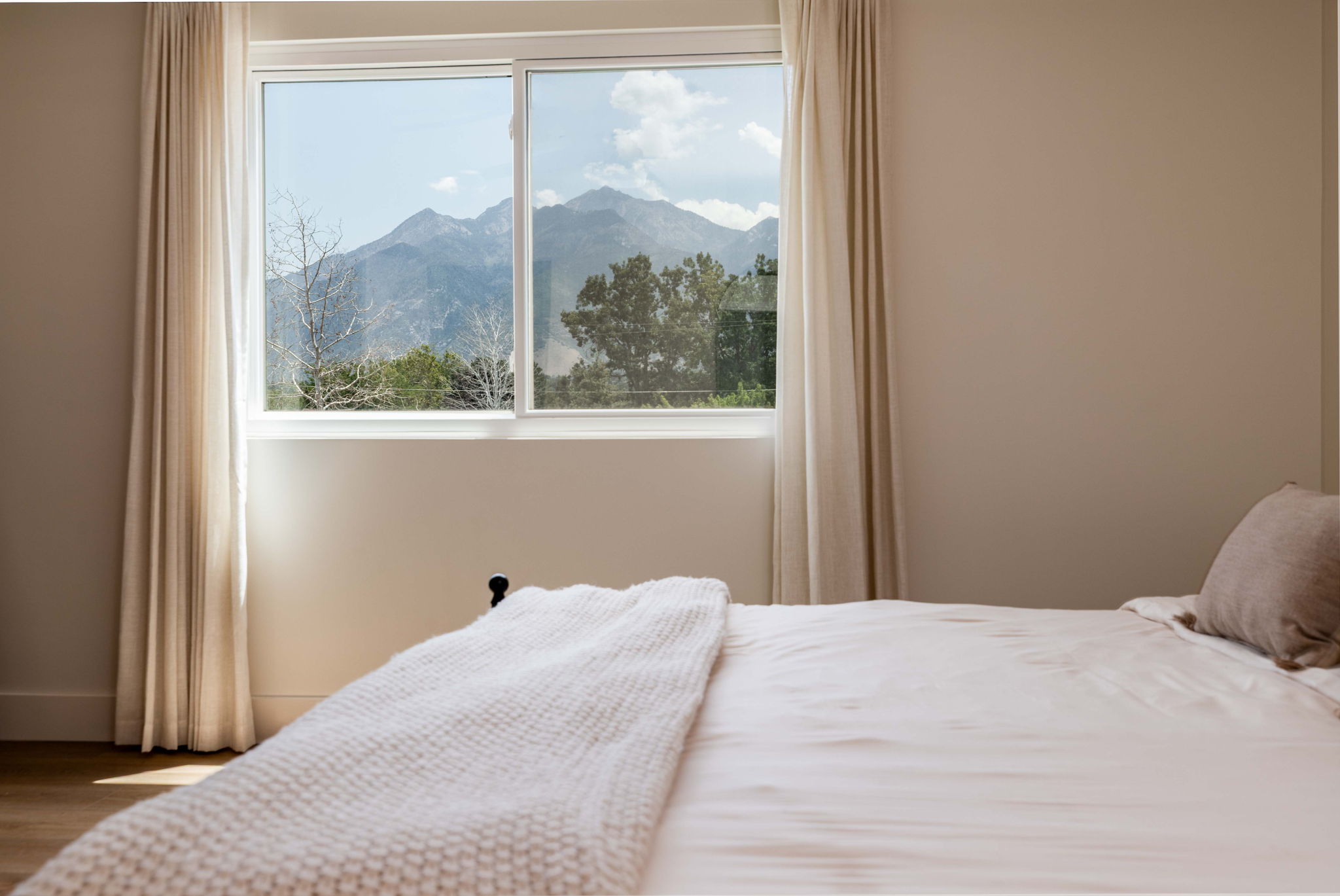 Bedroom featuring a large window with a mountain backdrop