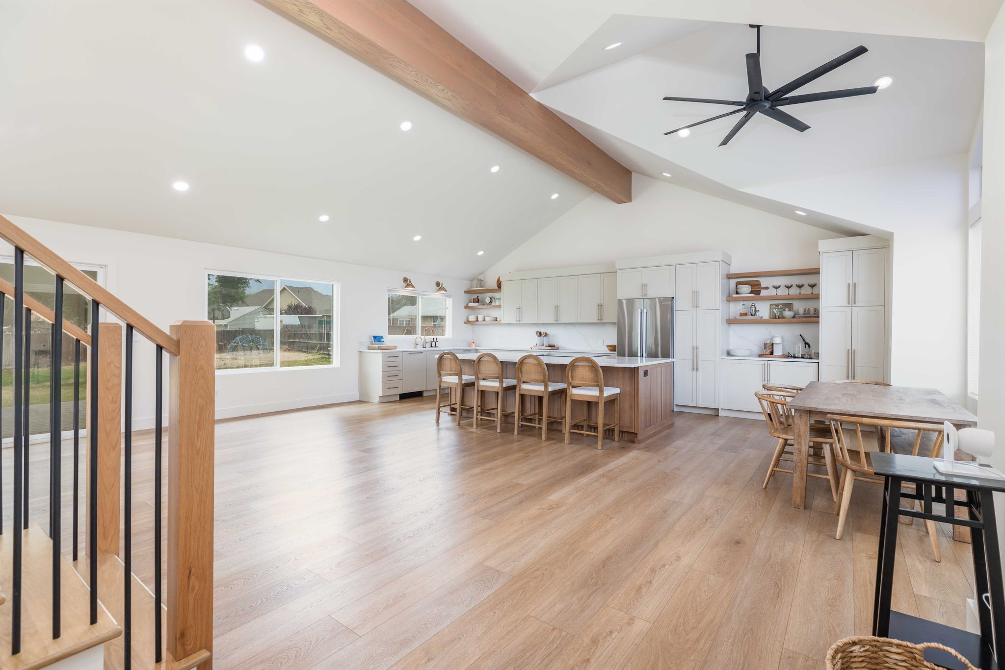 Open concept living space featuring wood-finish flooring, vaulted ceilings with a wood beam, and recessed lighting