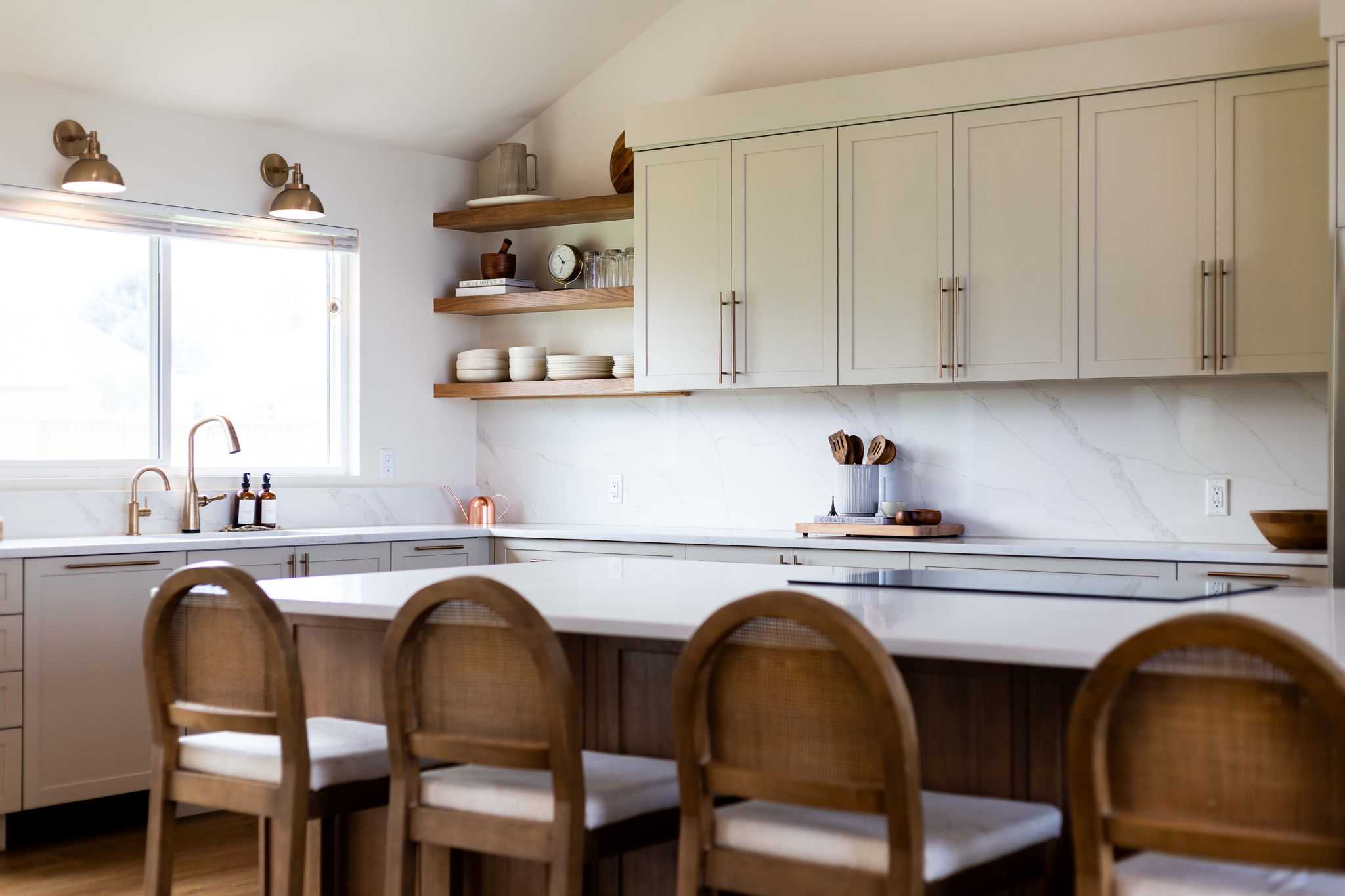 Modern kitchen featuring an expansive island with seating, a built-in cooktop, and a white countertop