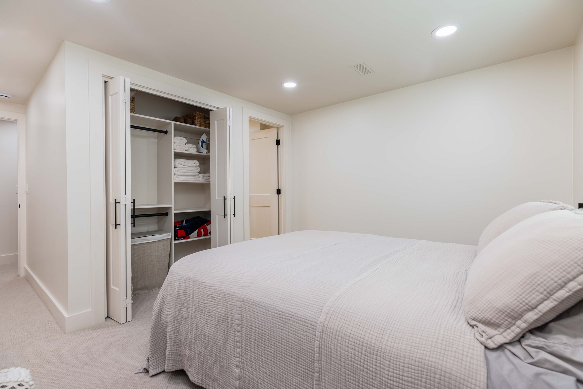 Bedroom featuring recessed lighting, a built-in closet with bifold doors, integrated shelving, and hanging rods