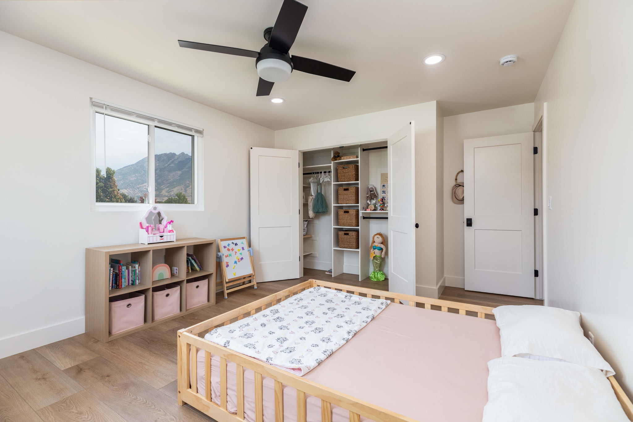 Bedroom featuring wood-finish flooring, a contemporary ceiling fan, recessed lighting, and a window with mountain scenery