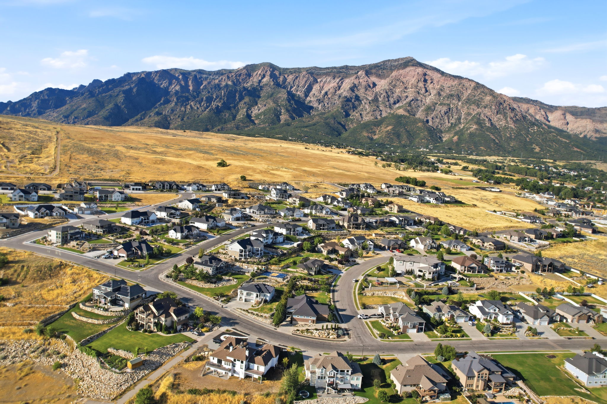 Expansive residential area featuring a diverse collection of single-family homes with varied architectural styles, paved roadways, and landscaped properties