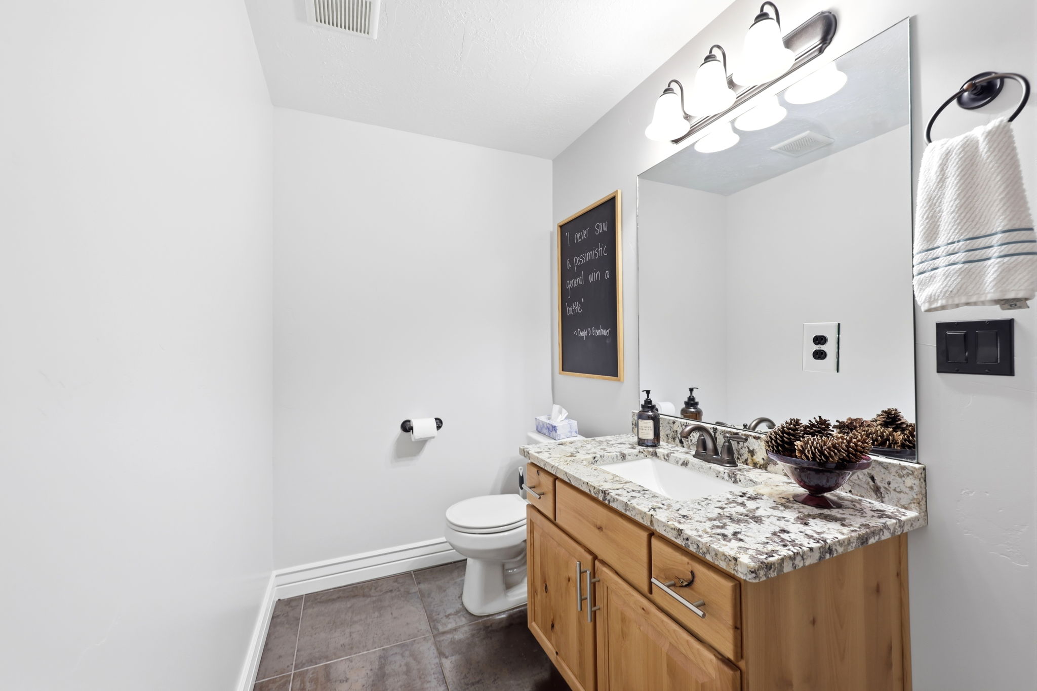 Bathroom featuring a wood vanity with integrated storage, granite countertop, undermount sink, and brushed nickel fixtures