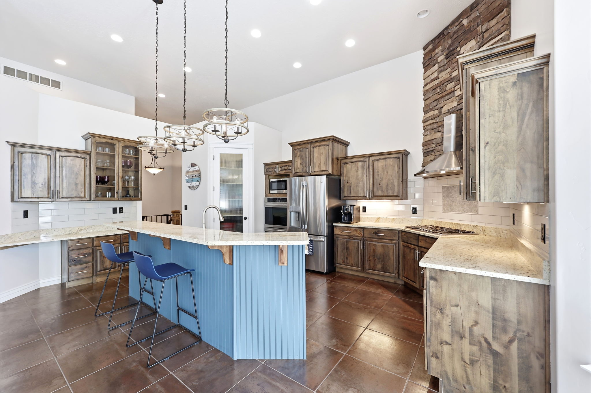 Spacious kitchen featuring a large island with beadboard paneling, granite countertops, and stainless steel appliances