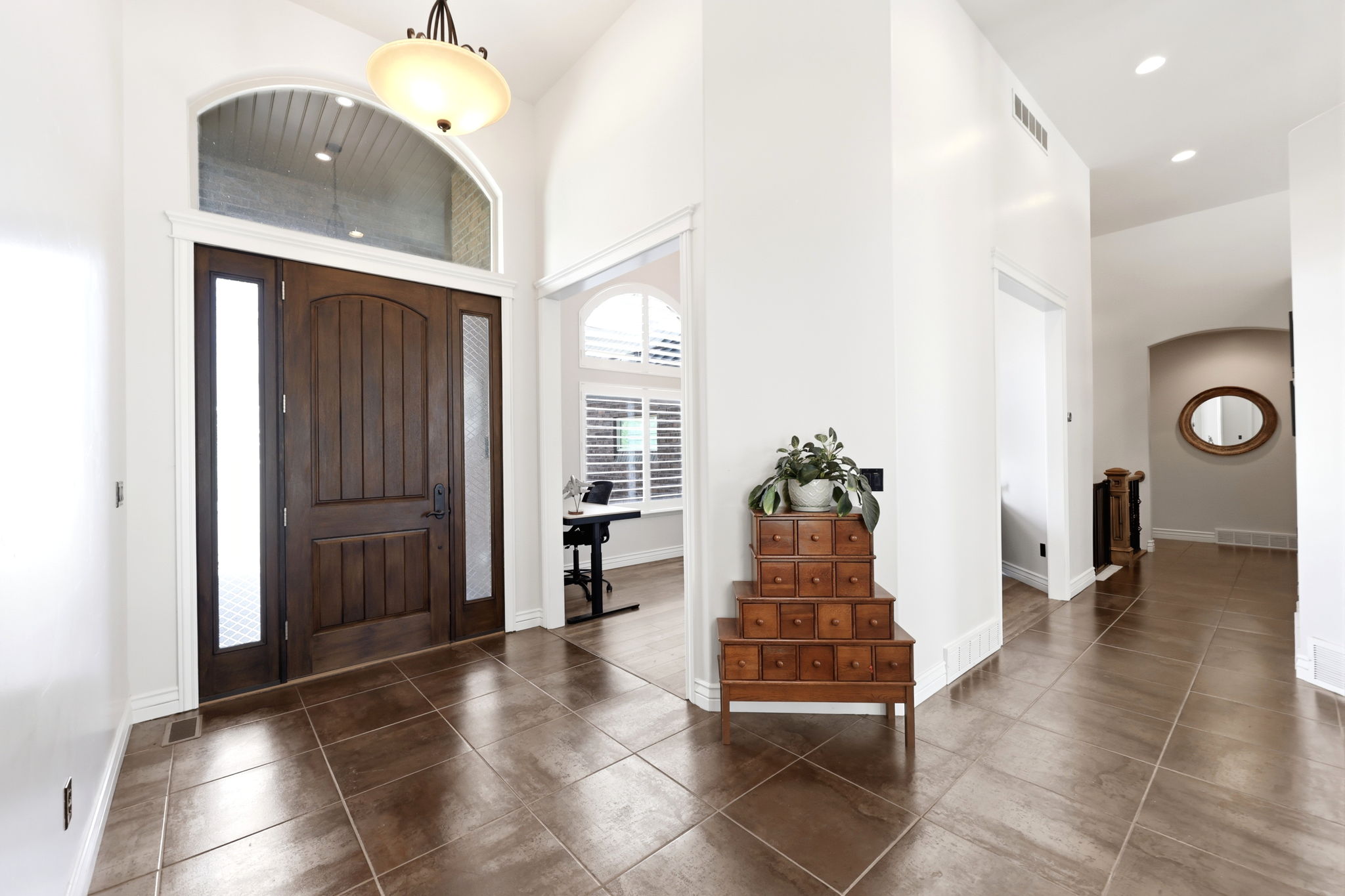 Entryway featuring a dark wood front door with side lites and an arched transom window
