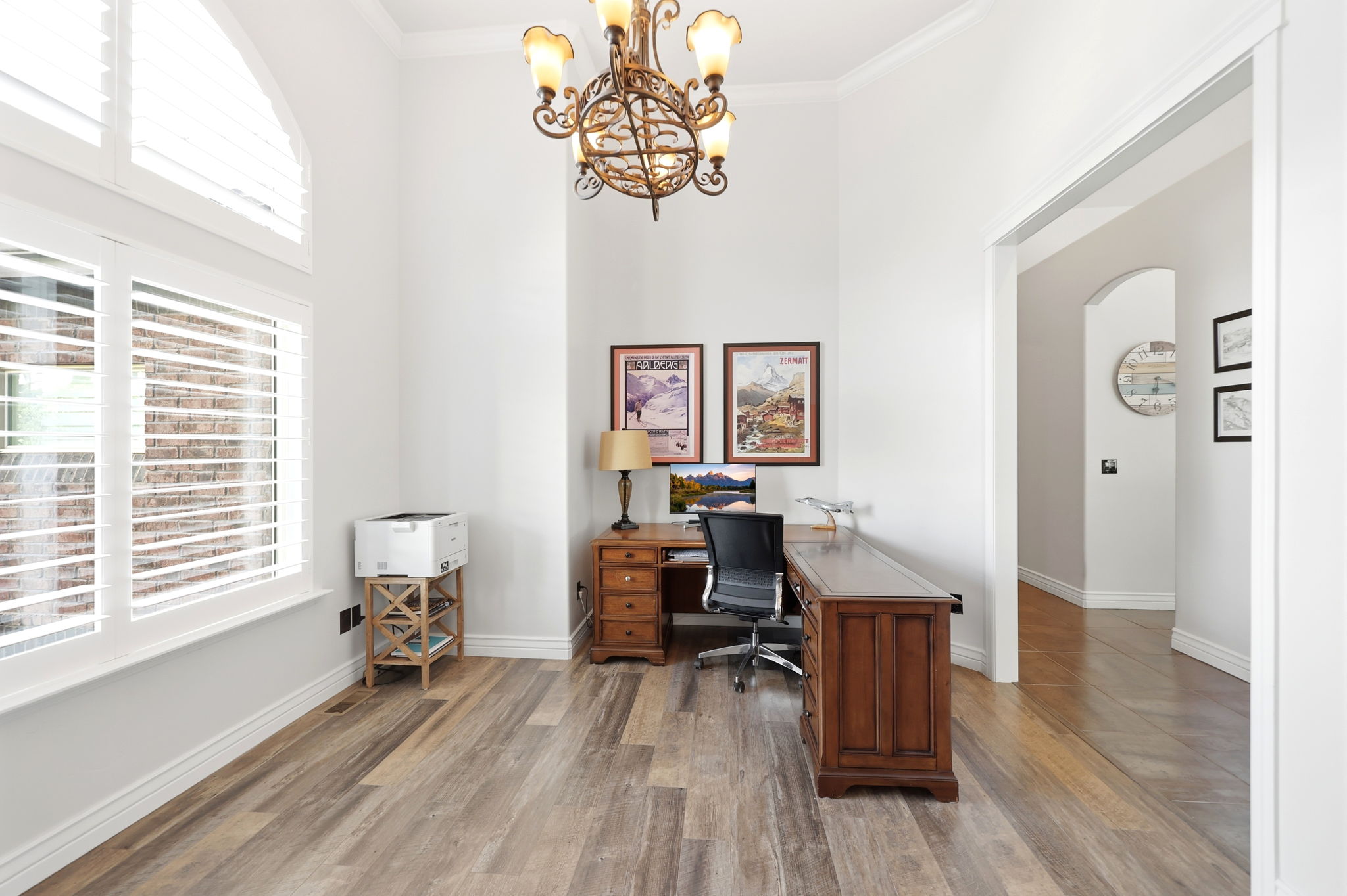 Spacious room featuring wood-finish flooring and high ceilings with crown molding