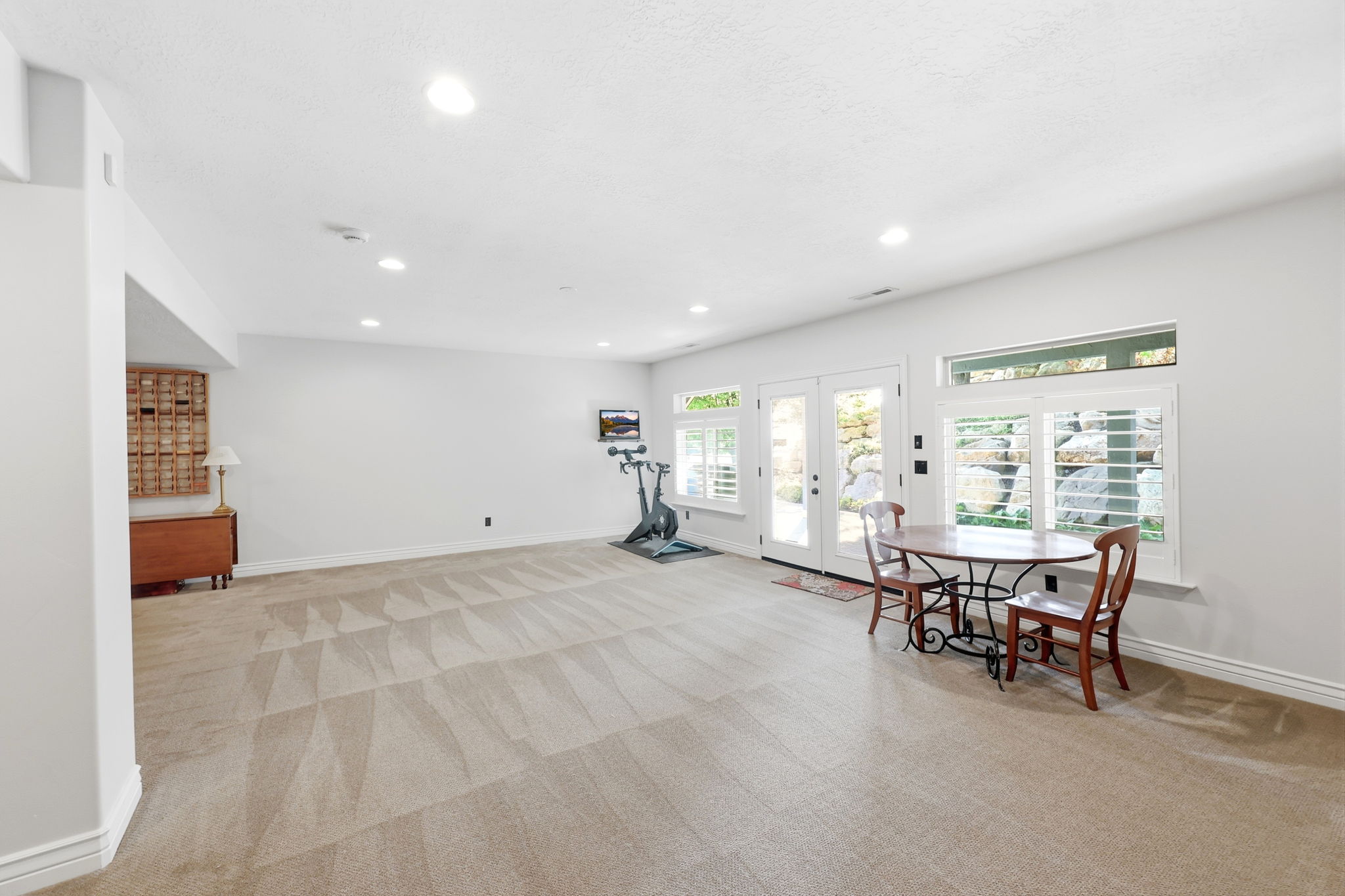 Spacious room featuring light neutral wall paint and plush carpeting