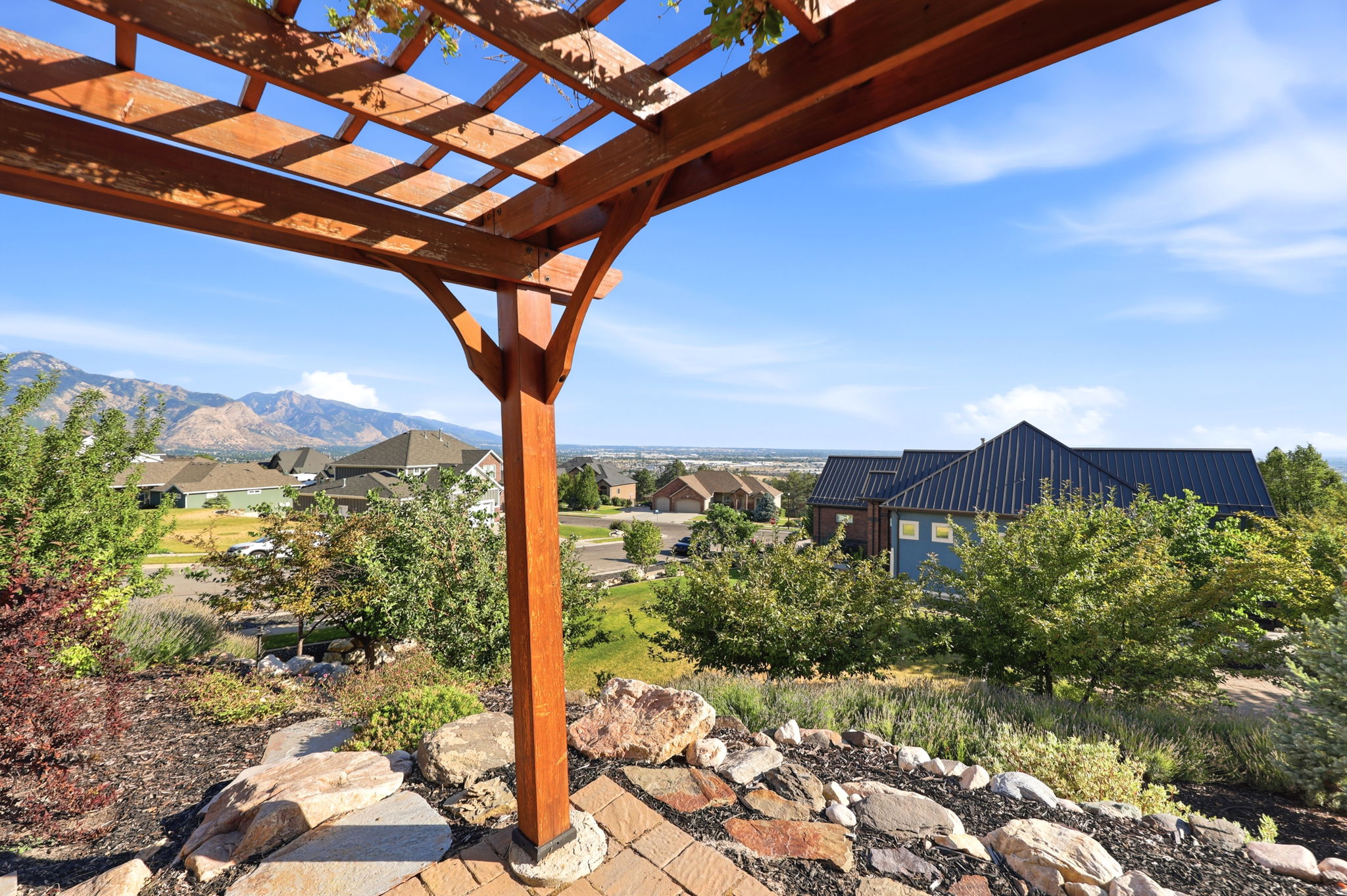 Wood pergola structure with visible mountain and community backdrop