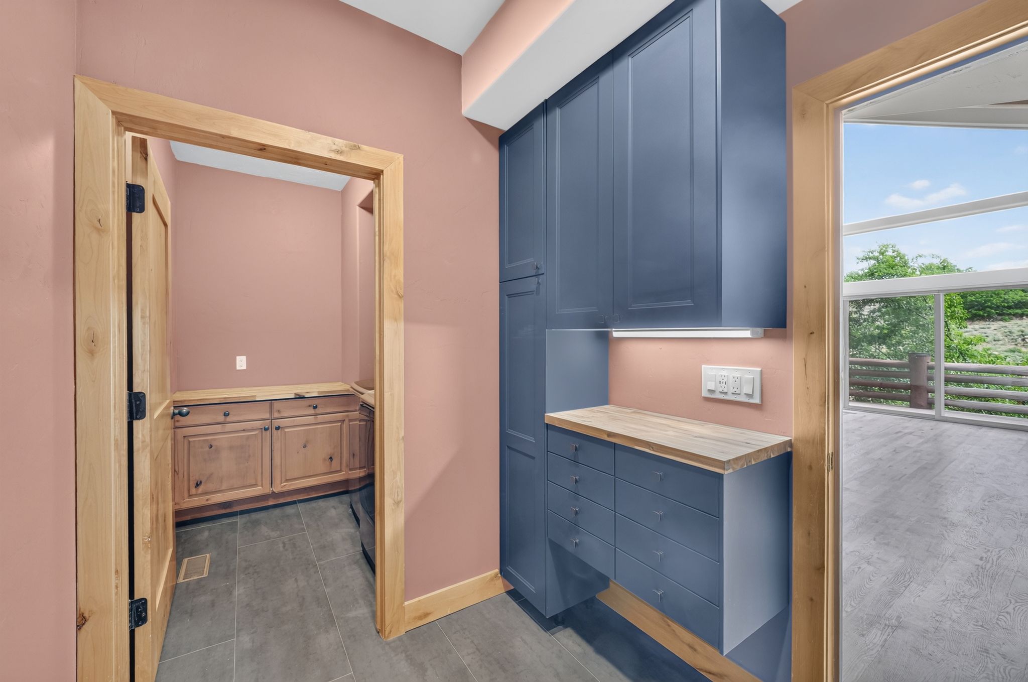 Built-in blue cabinetry with wood-finish countertops, under-cabinet lighting, and integrated electrical outlets