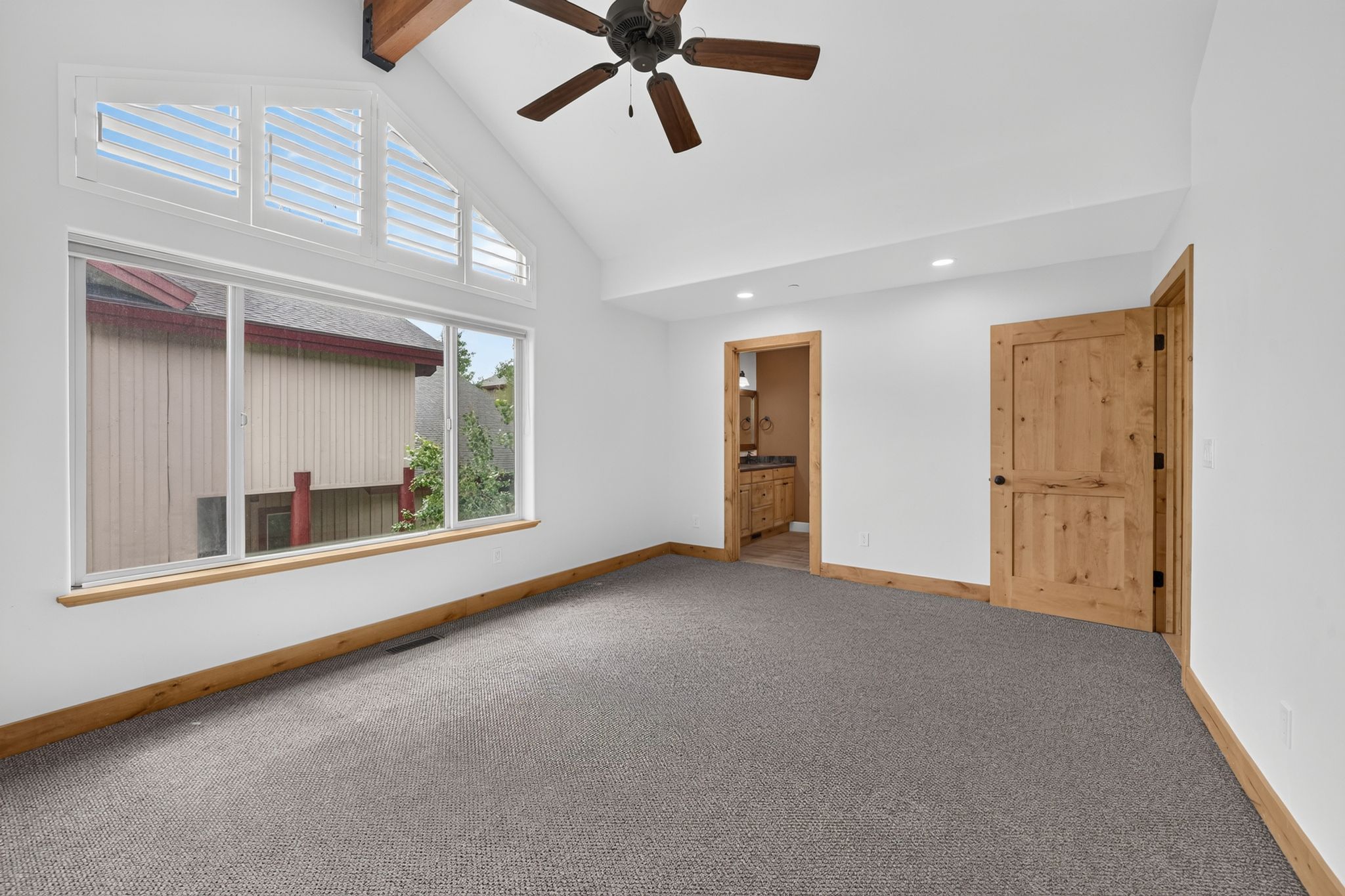 Vaulted ceilings with exposed wood beams and a ceiling fan