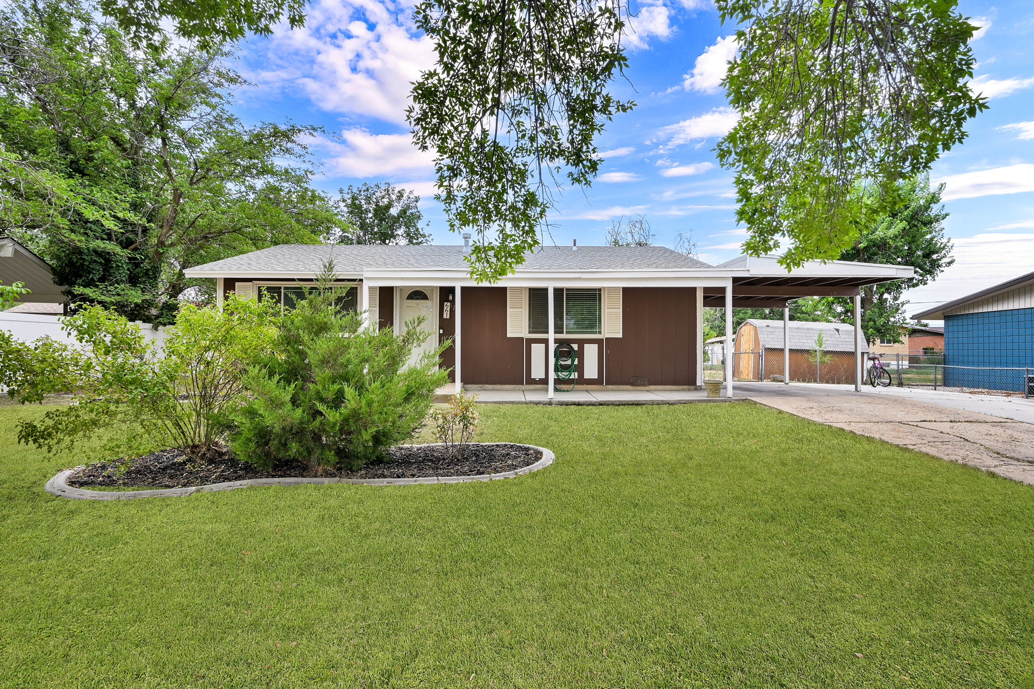 Brown single-story residence featuring a white front door and window trim