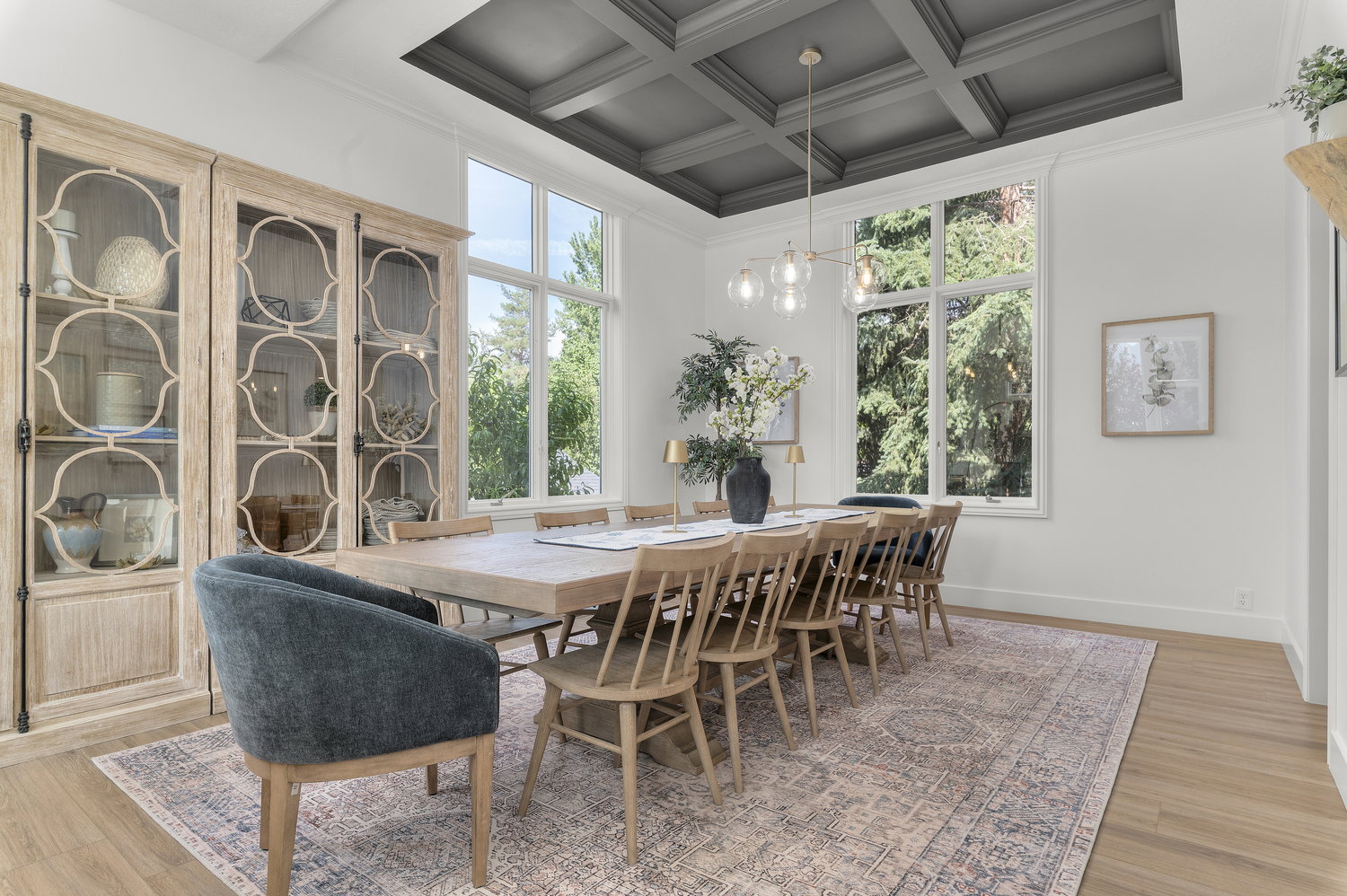 Dining area featuring a coffered ceiling, large windows, wood-finish flooring, and a contemporary chandelier