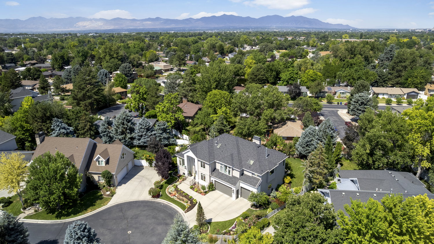 Suburban residential neighborhood with mature trees and mountain backdrop