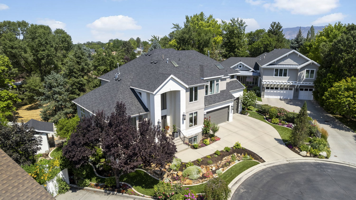 Two-story residence featuring a dark shingle roof and light-colored siding