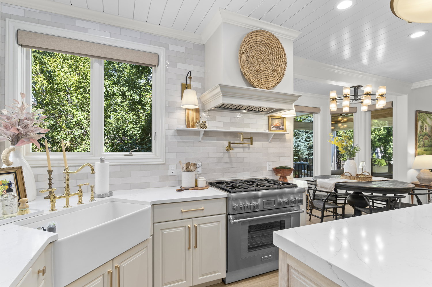 Gourmet kitchen featuring a farmhouse sink, stainless steel range with pot filler, white shaker-style cabinetry, and a shiplap ceiling