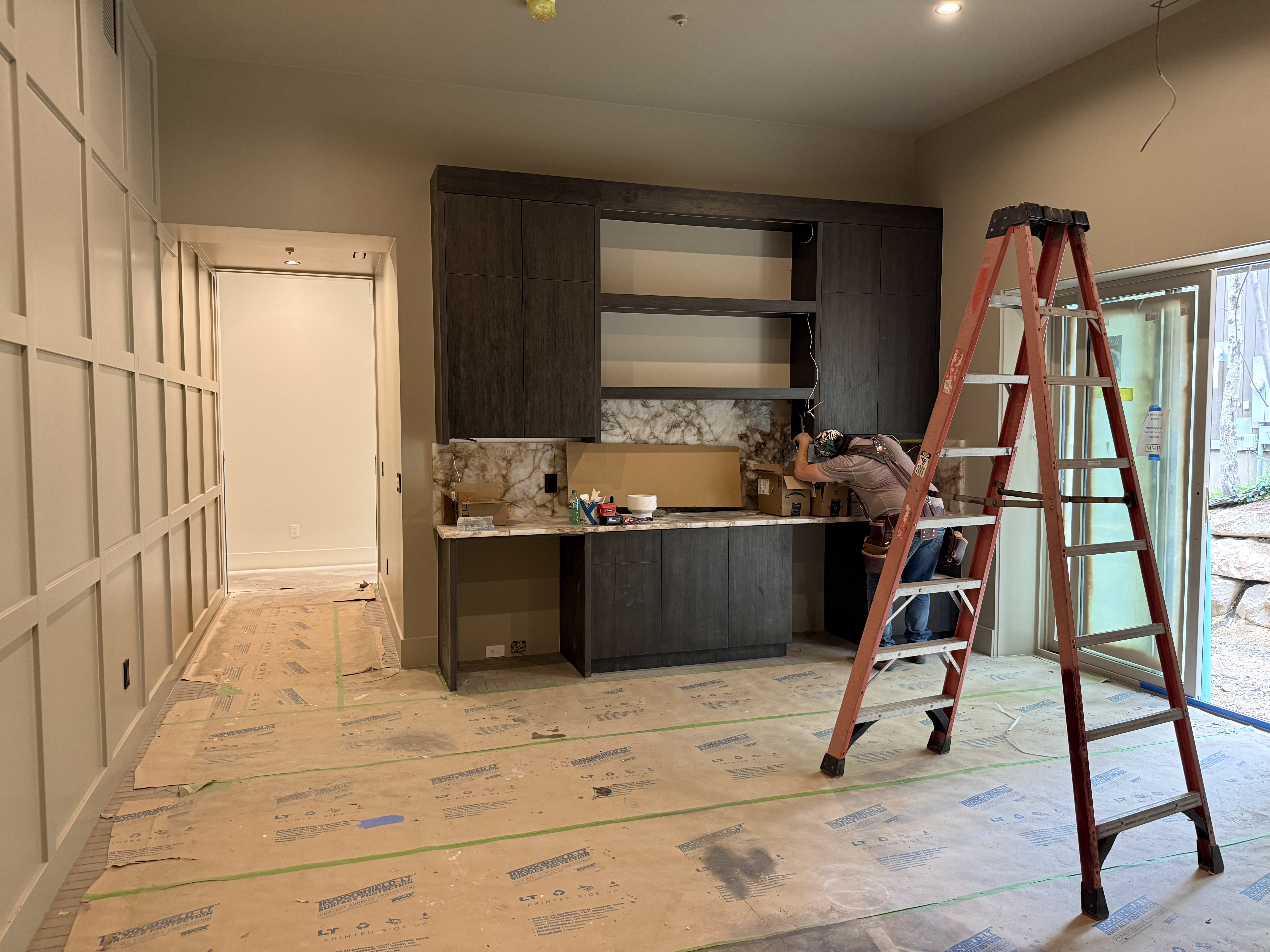 Built-in cabinetry with open shelving and a stone backsplash