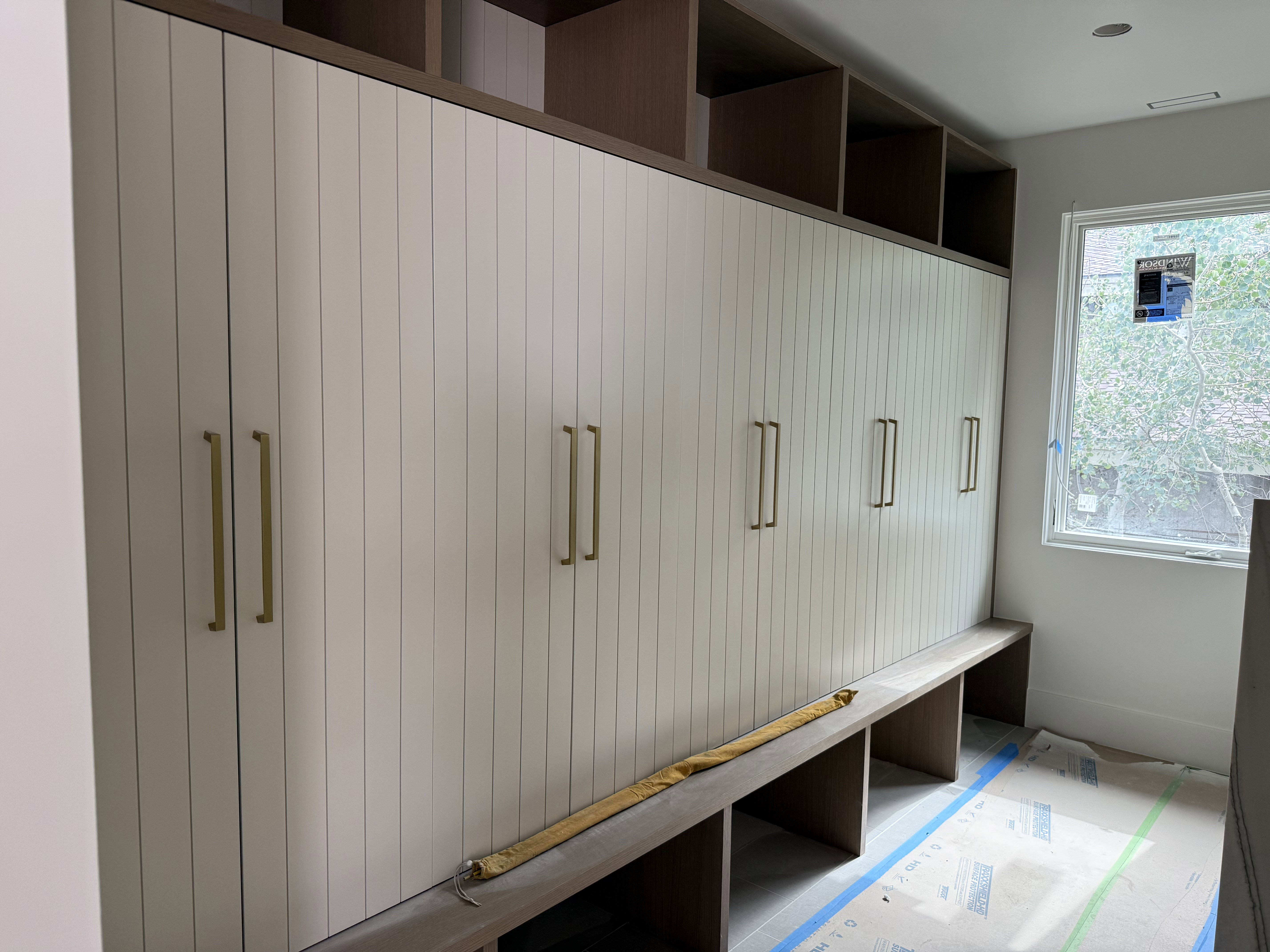 Full-height built-in cabinetry with paneled doors and brass hardware