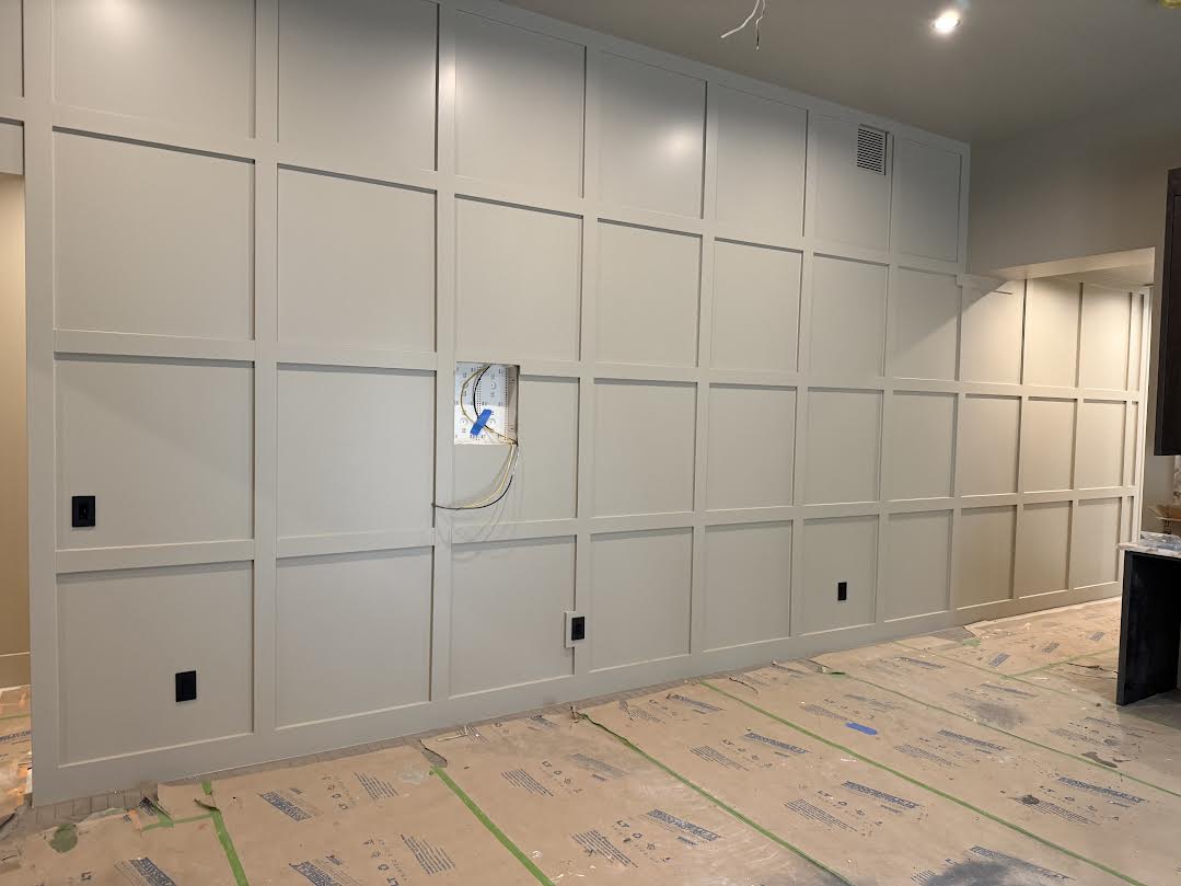 Extensive grid paneling detailing the walls, complemented by recessed ceiling lighting and dark-finished cabinetry