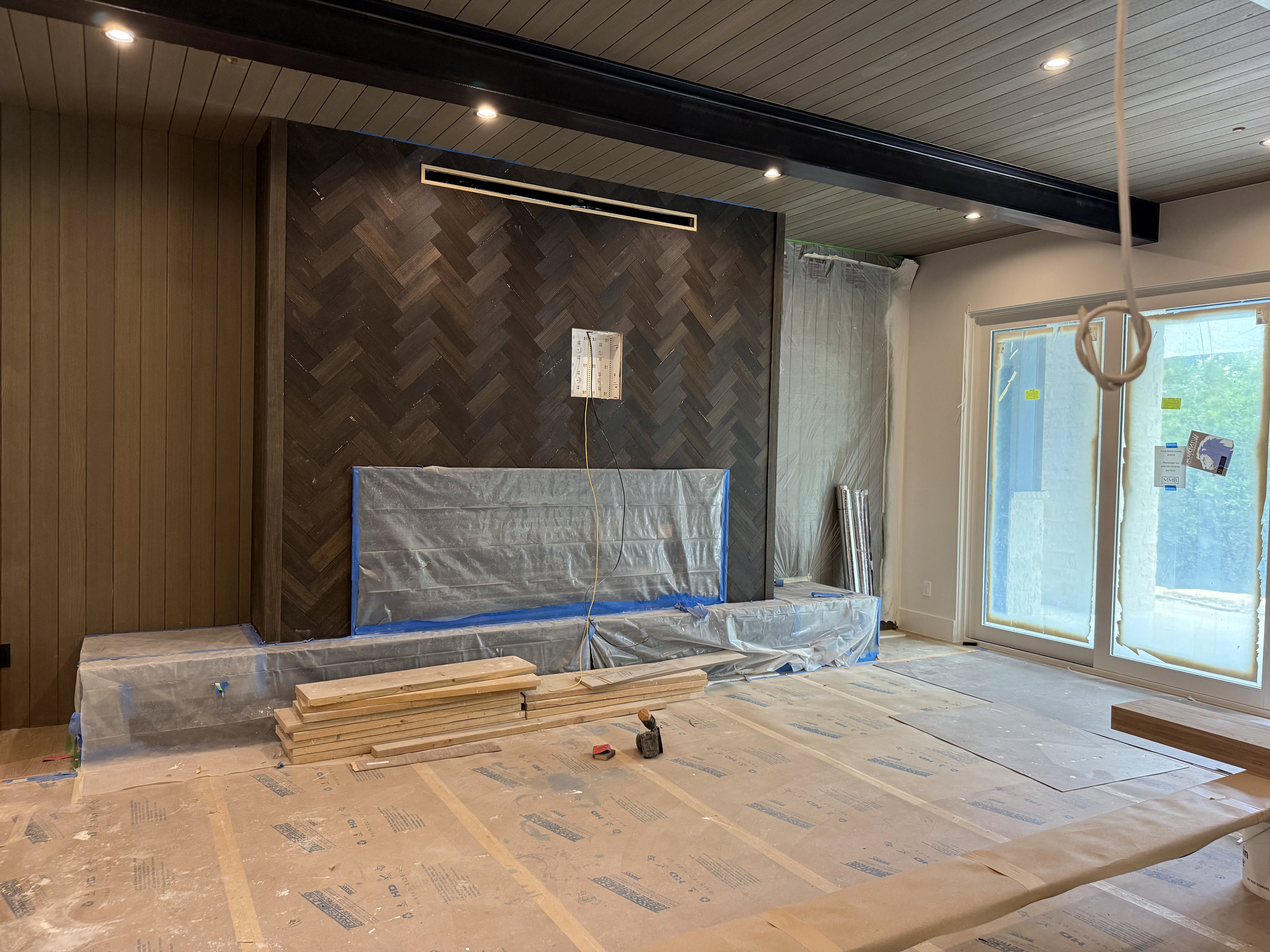 Herringbone wood-finish accent wall with a built-in hearth