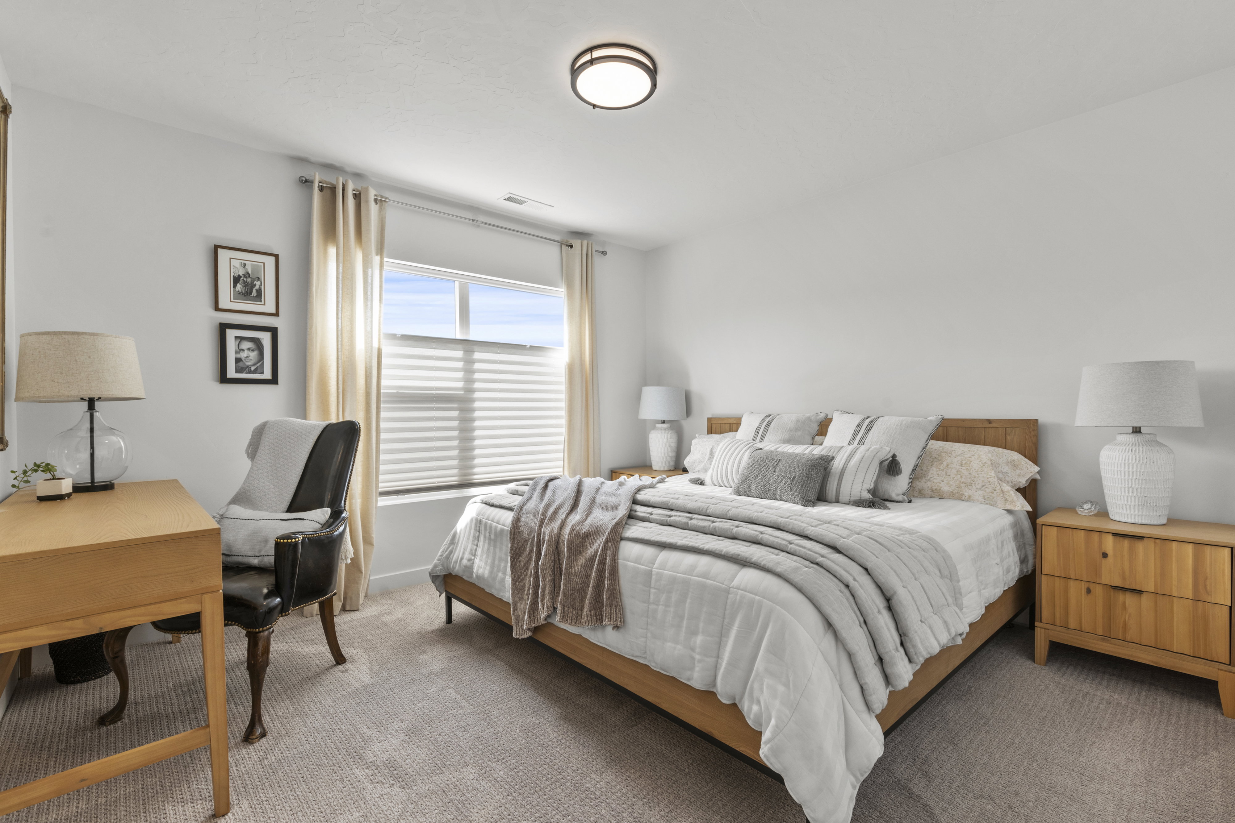 Carpeted room featuring a large window with blinds and drapes, a flush-mount ceiling light, and light-toned walls