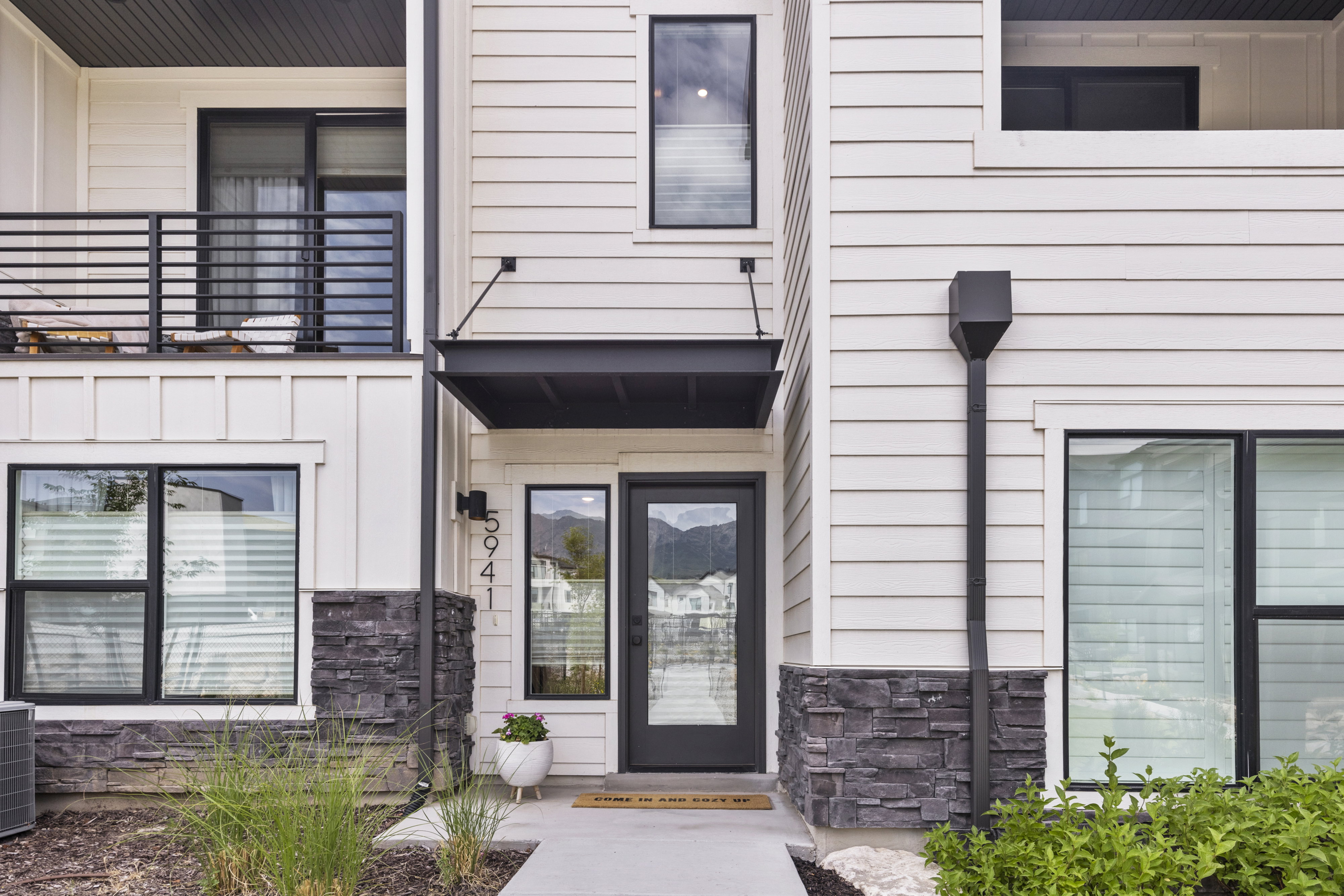 Modern facade featuring horizontal siding and dark stone veneer accents