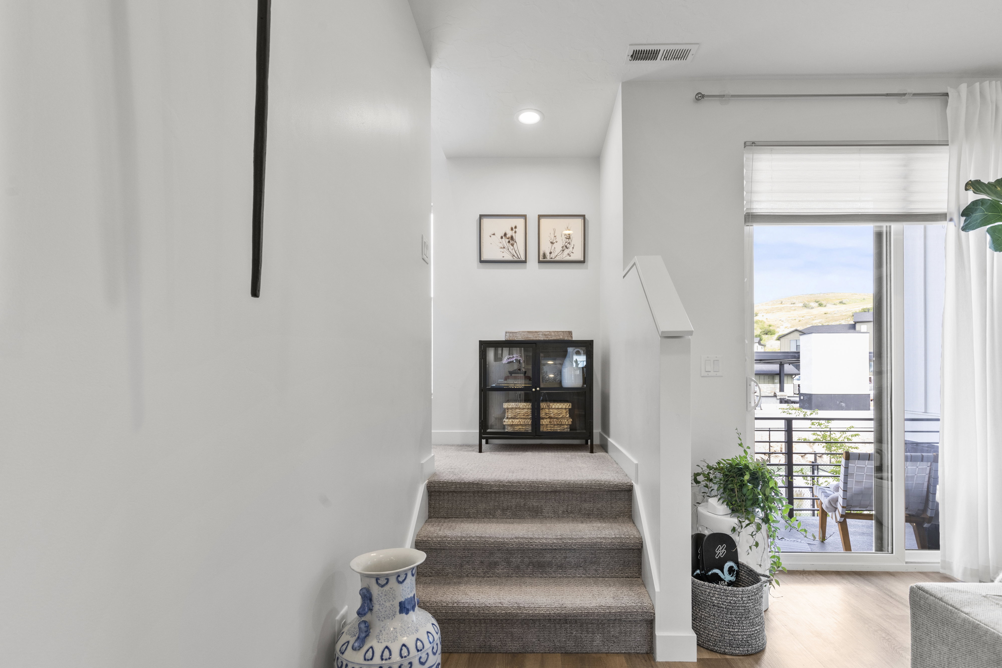 Carpeted staircase with white risers and handrail