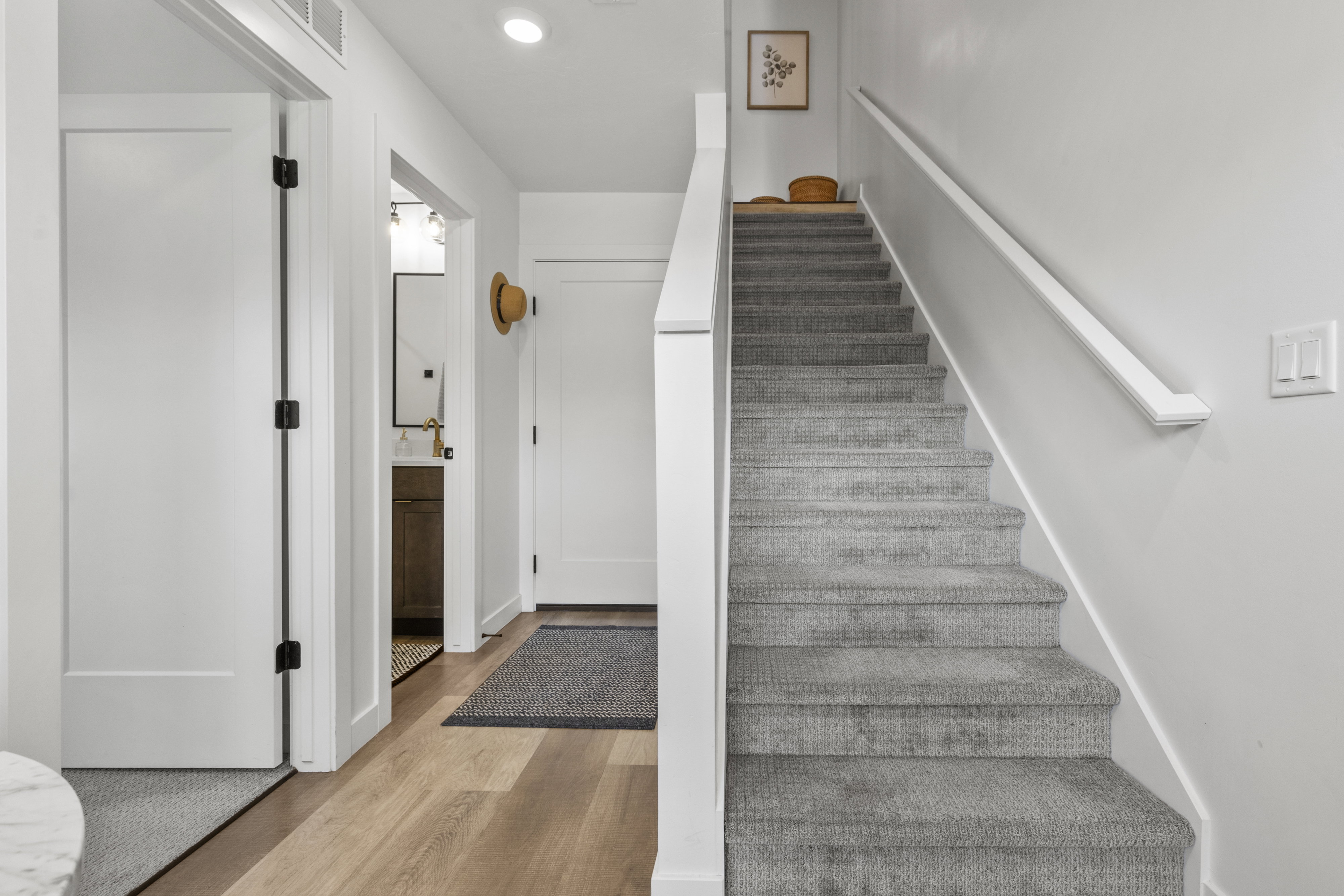 Carpeted staircase with white handrail