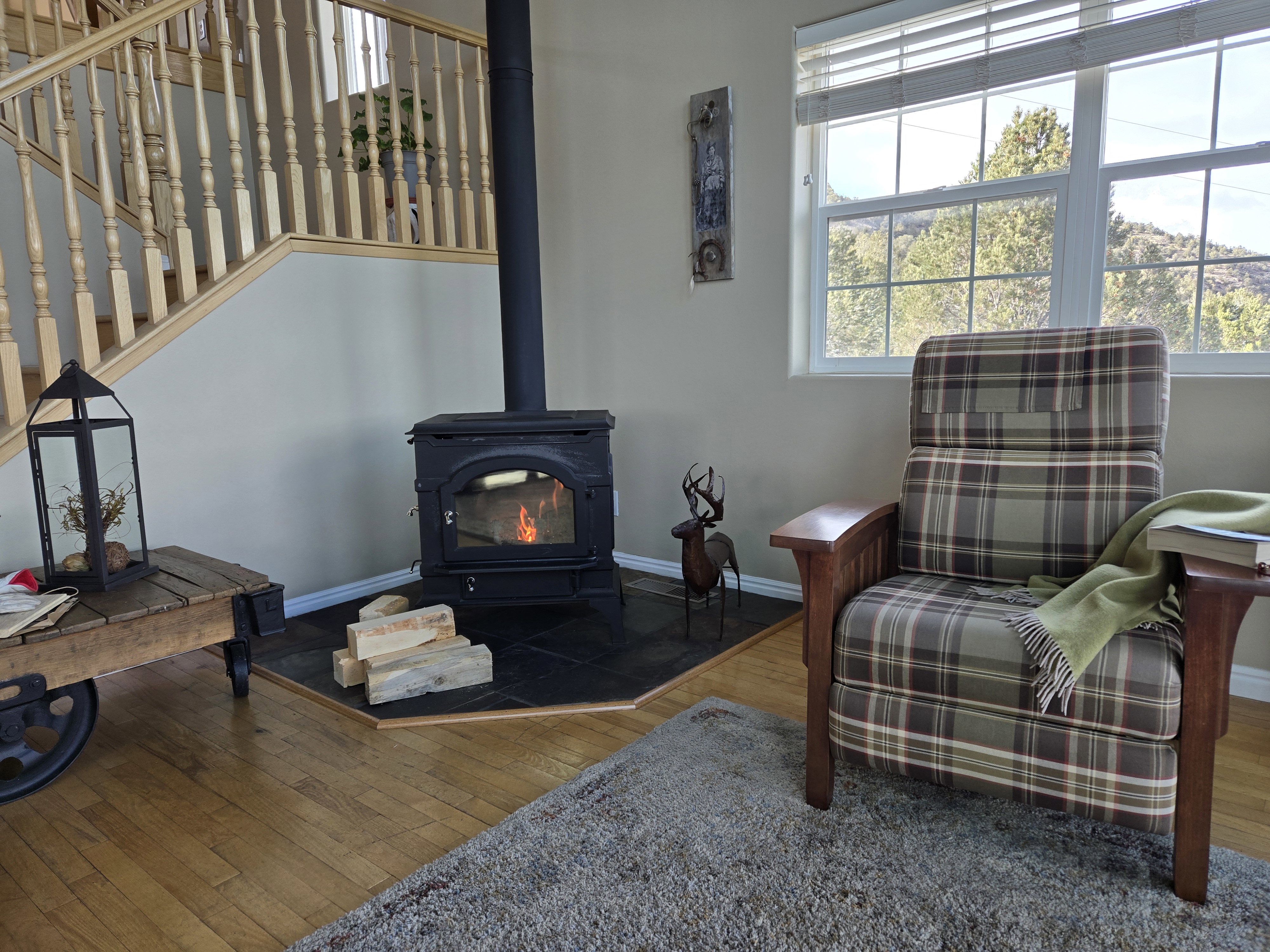 Freestanding wood stove with a tiled hearth, bordered by light wood-finish flooring
