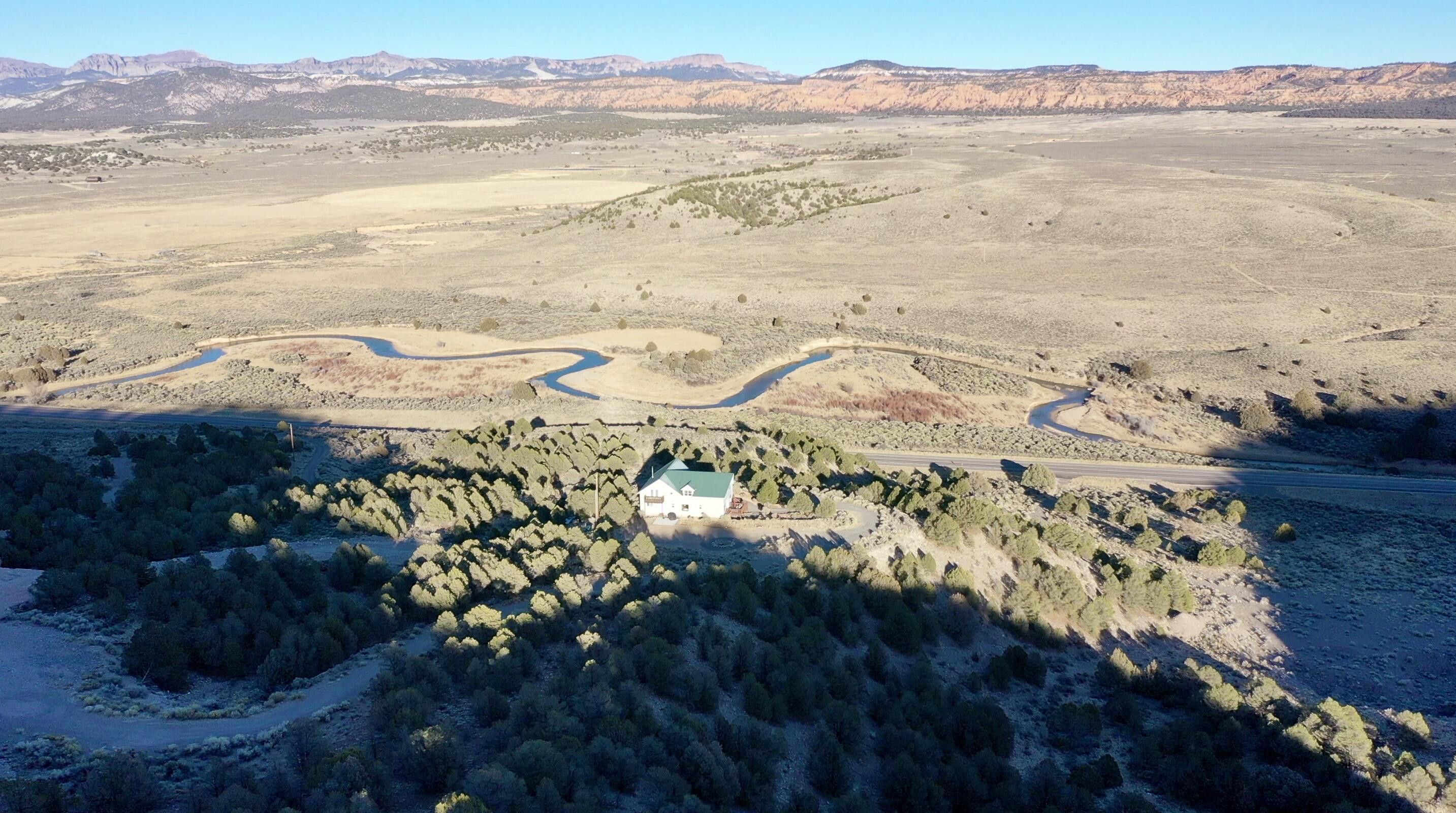 White residence with a green roof, set among natural desert landscaping