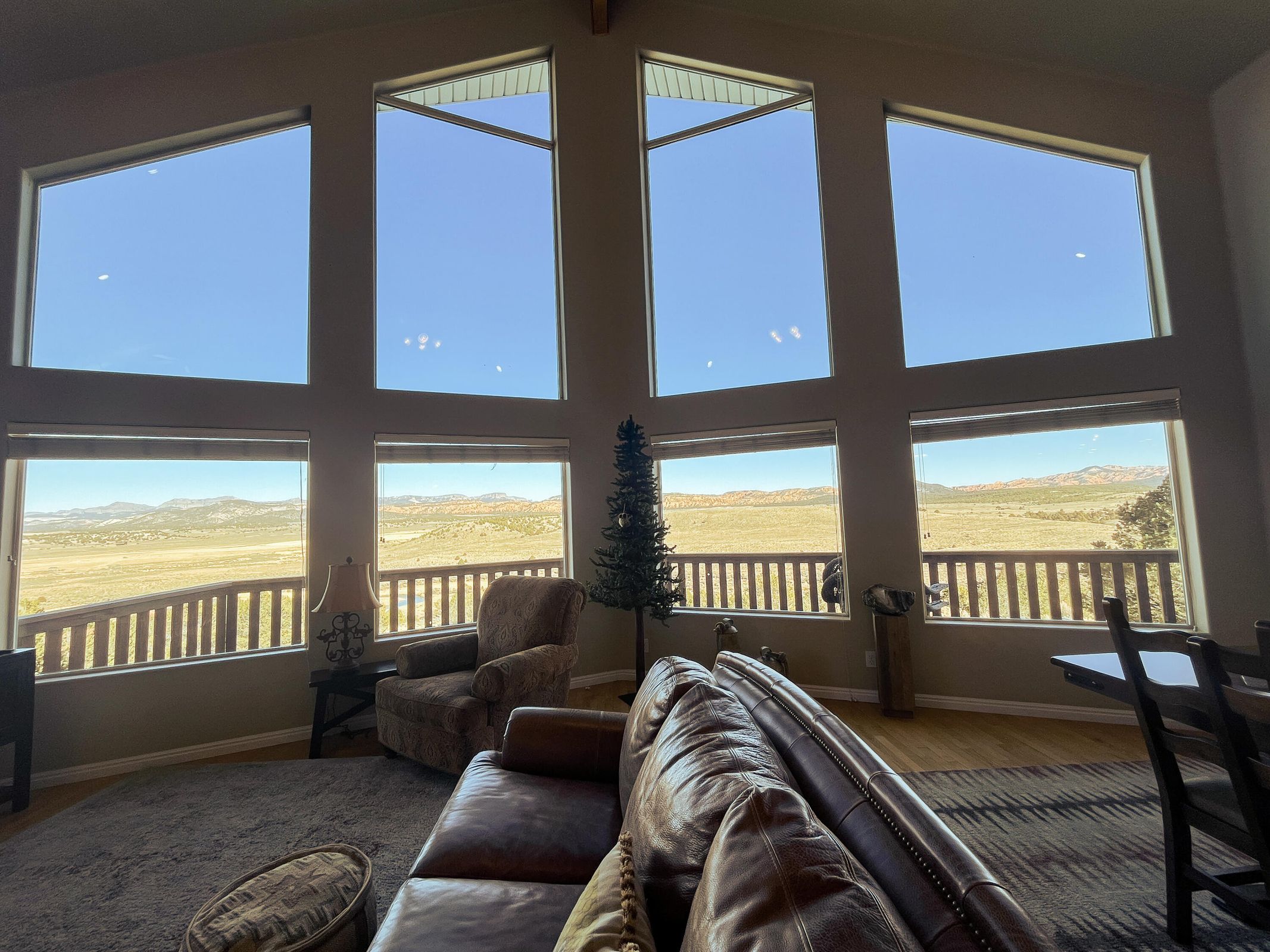 Vaulted great room with expansive window wall showcasing distant mountain and desert scenery
