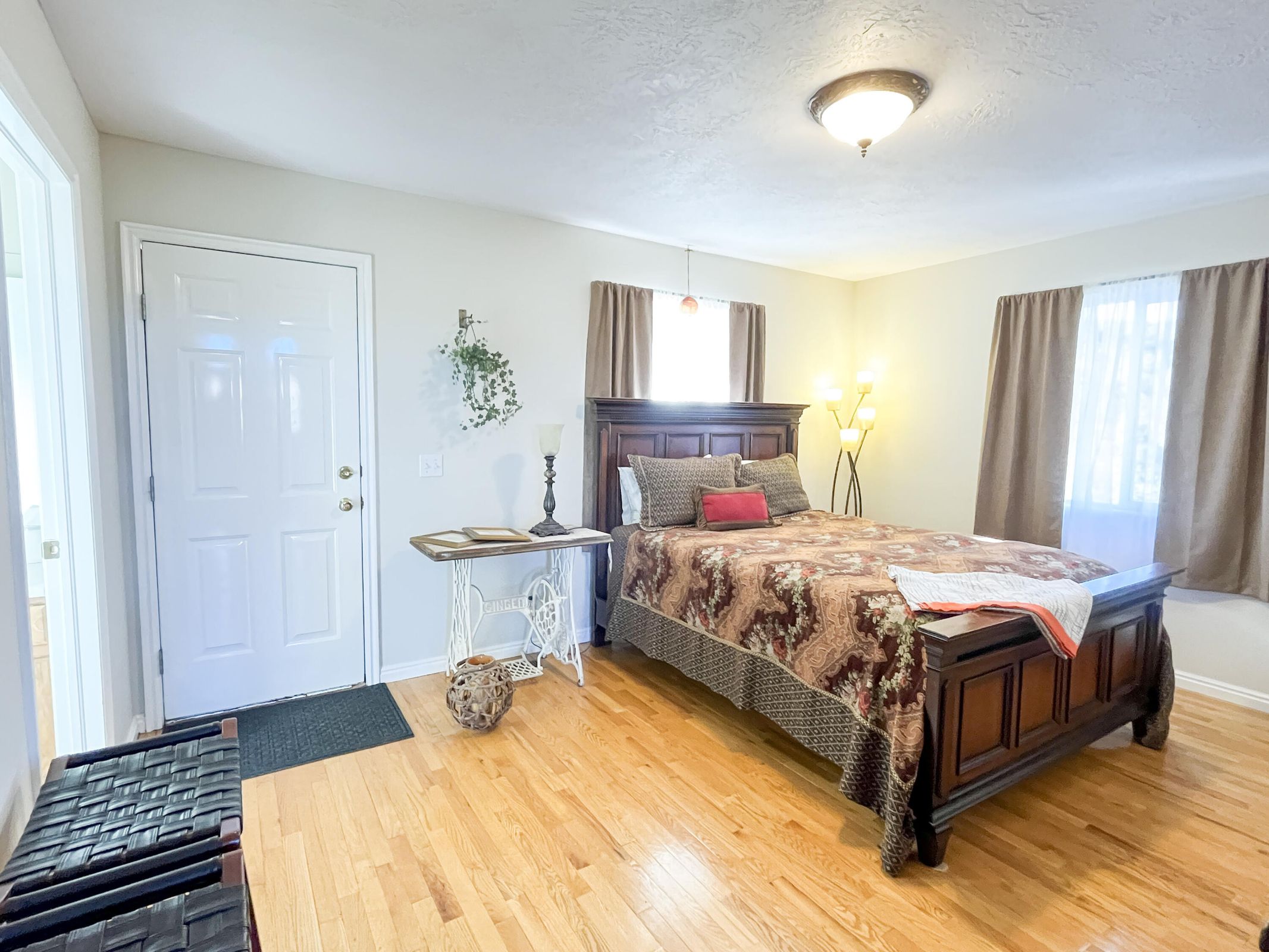 Light wood-finish flooring complements neutral wall tones and a white paneled door