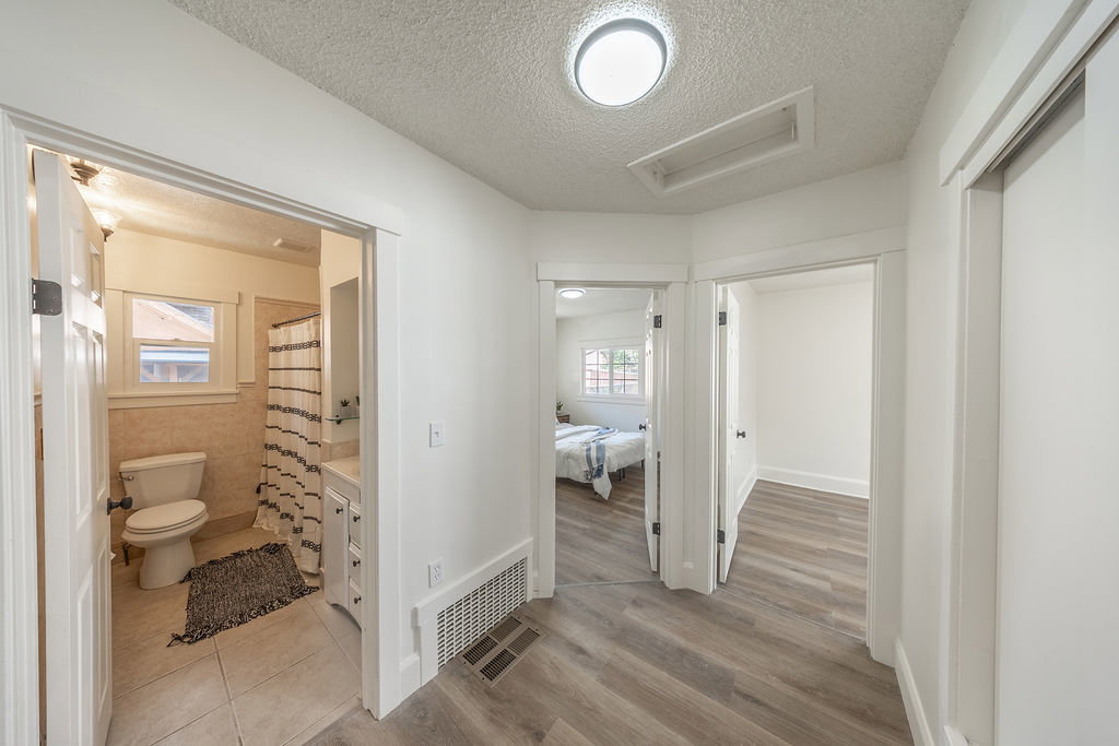 Hallway featuring wood-finish flooring, white walls, and recessed lighting