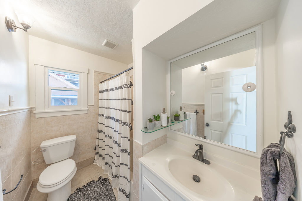 Bathroom featuring a white vanity with an integrated sink, dark bronze faucet, and a large wall-mounted mirror