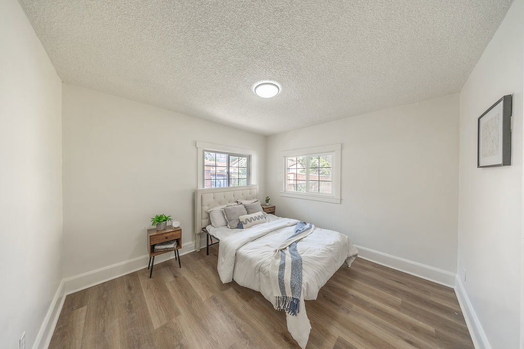 Room featuring wood-finish flooring, white baseboards, and bright white walls