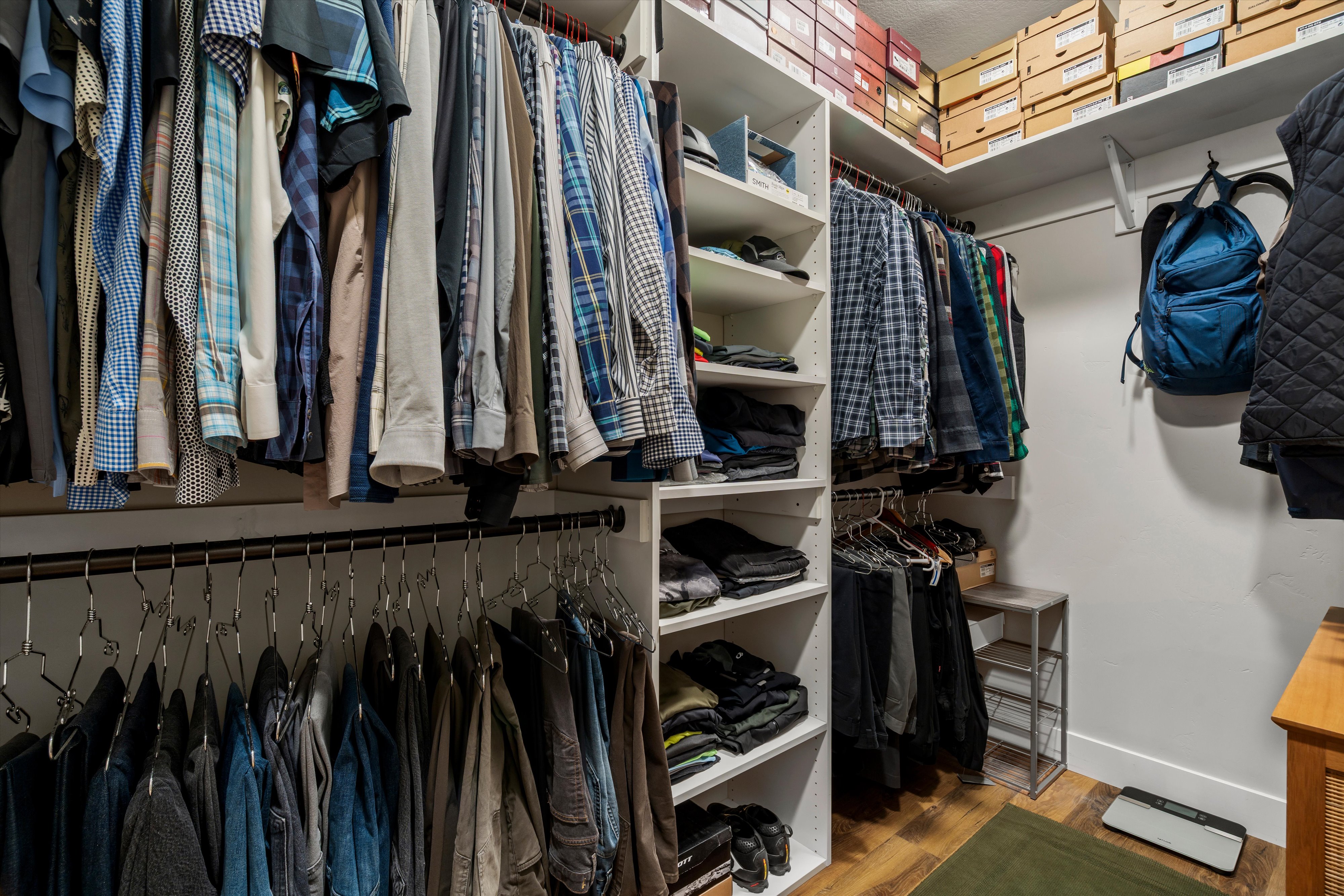 Customized closet system featuring multiple hanging rods and integrated shelving
