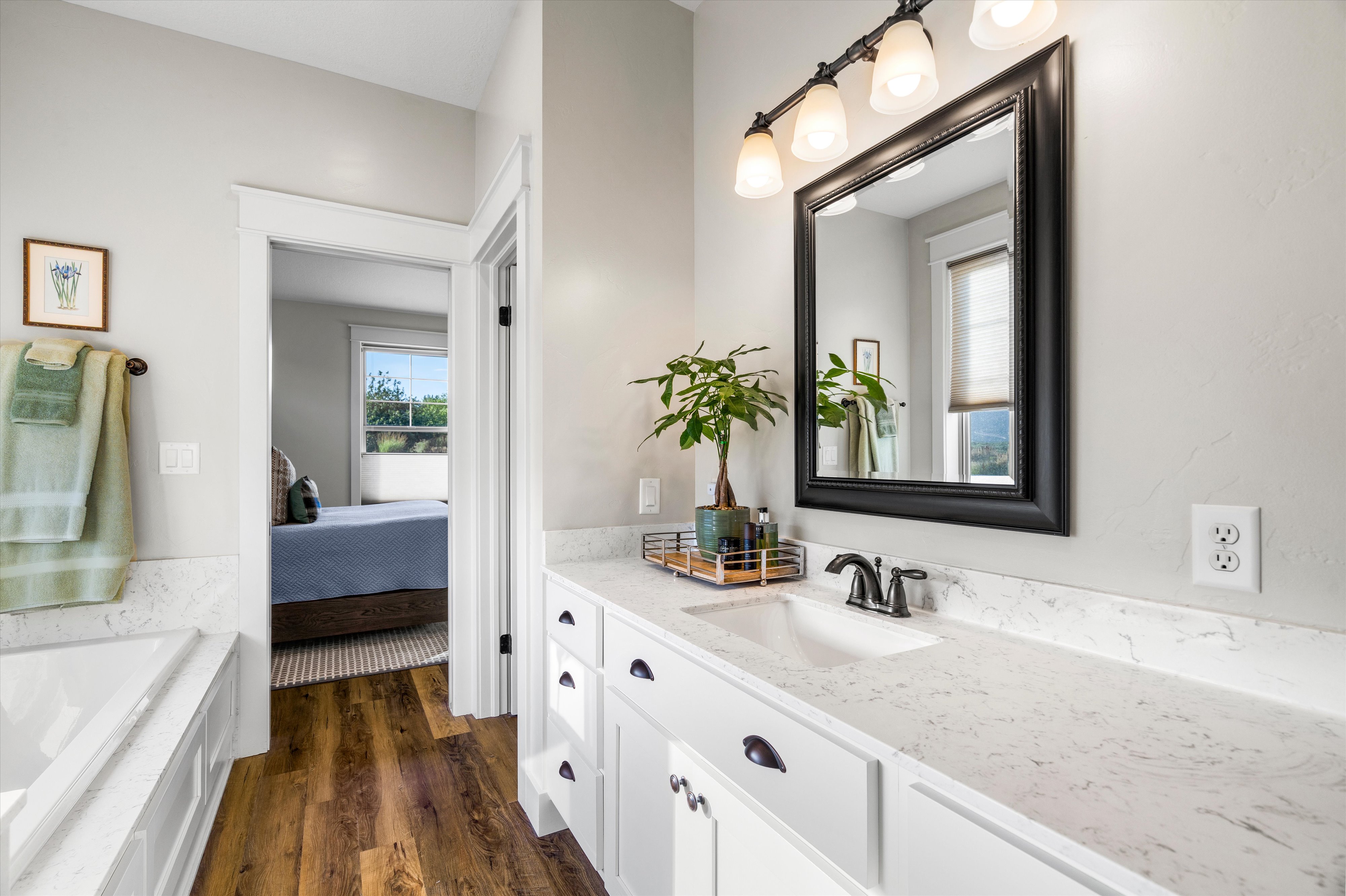 Bathroom featuring a white vanity with integrated sink, stone-finish countertop, and dark hardware