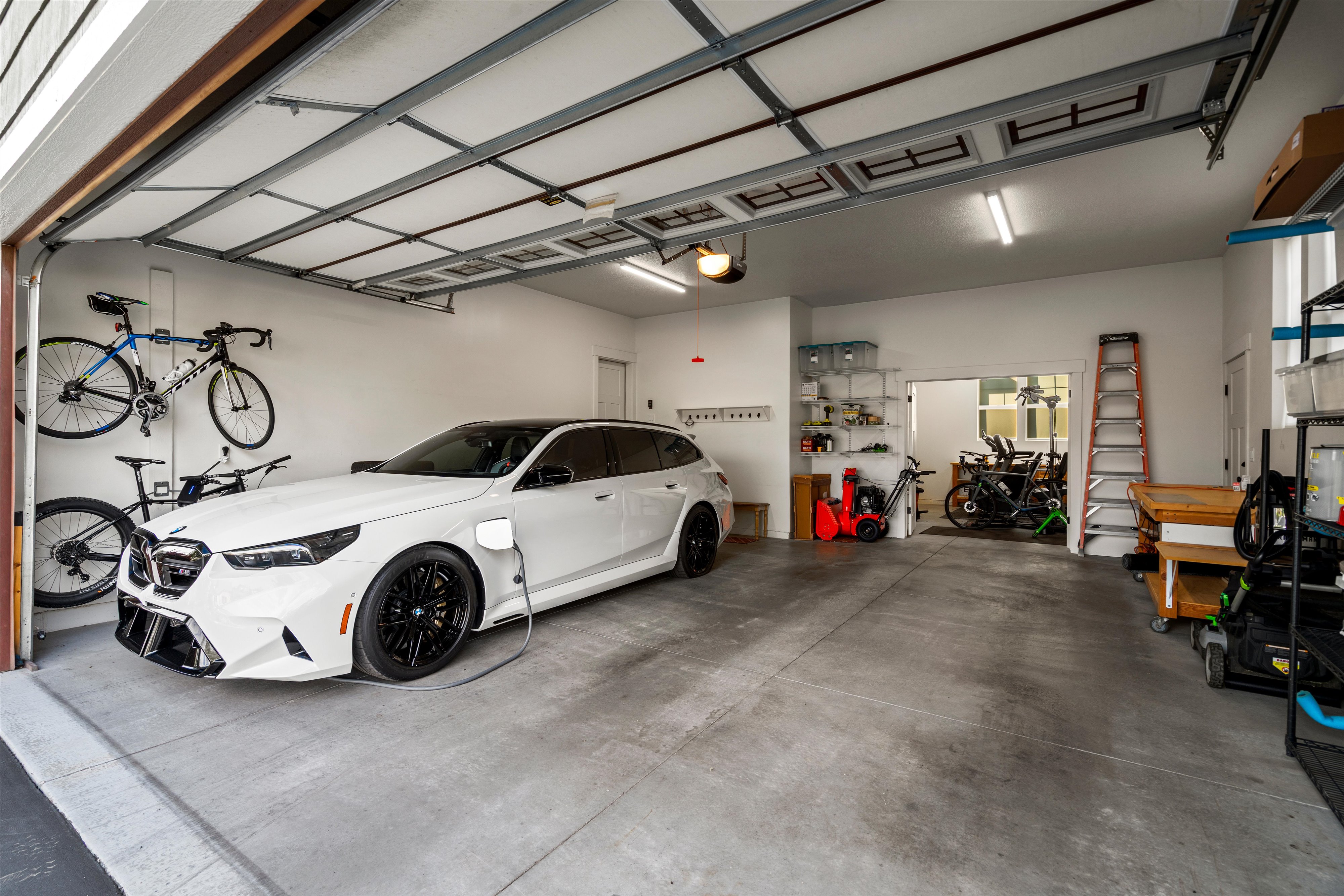 Spacious garage featuring a concrete floor, bright overhead lighting, and white painted walls