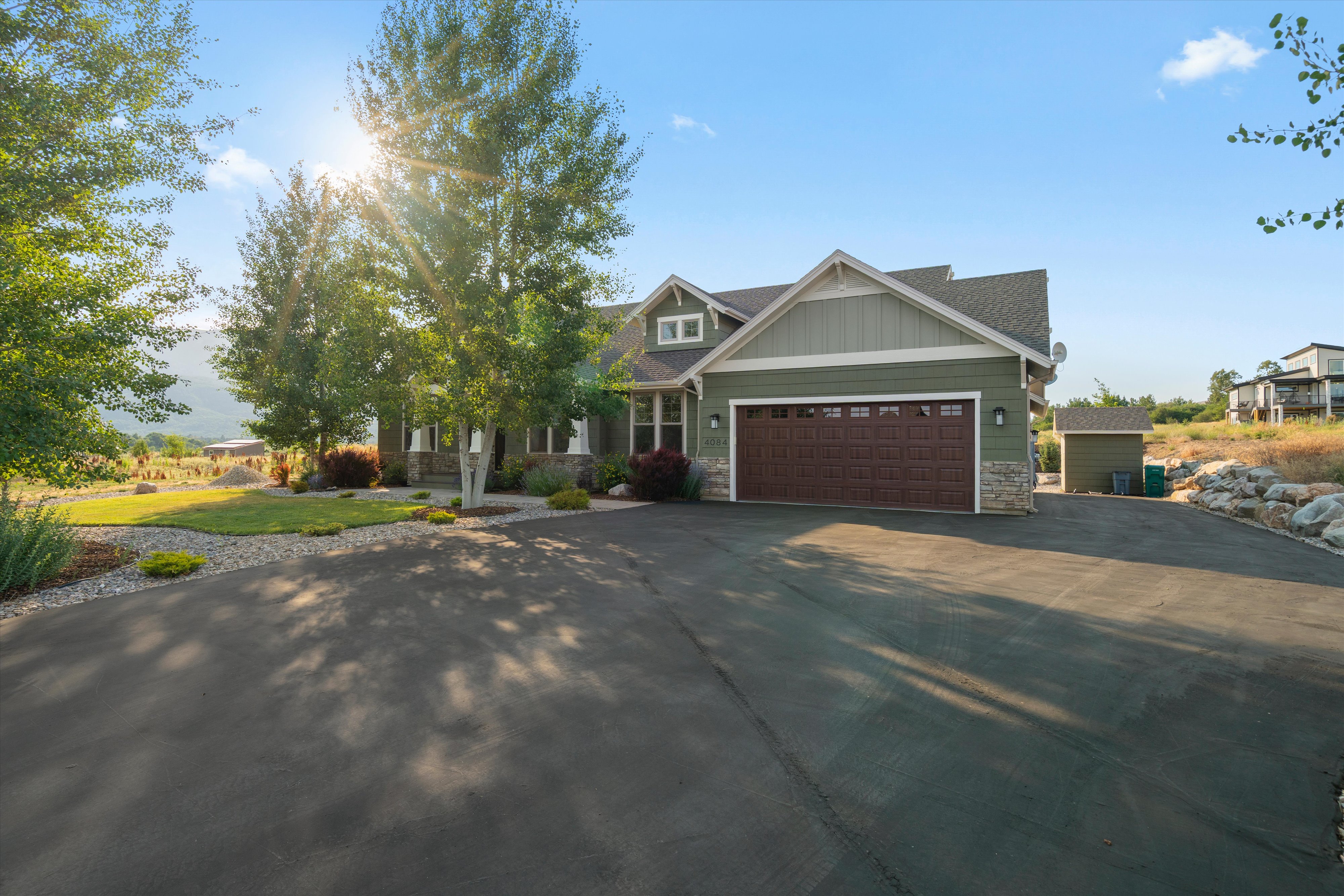 Paved driveway with an attached two-car garage featuring a rich wood-finish door