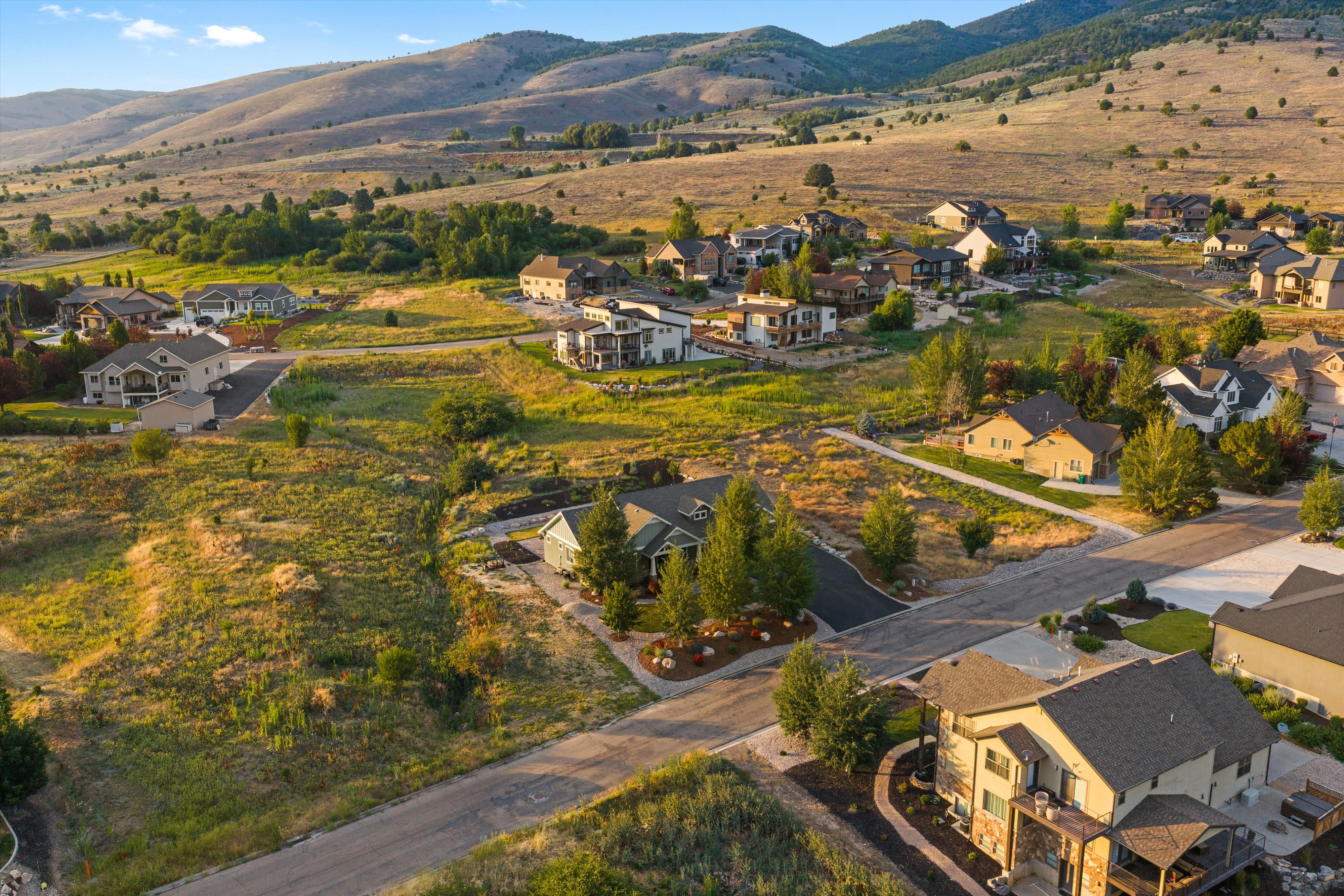 Expansive suburban development featuring various architectural styles, paved roadways, and surrounding natural landscapes