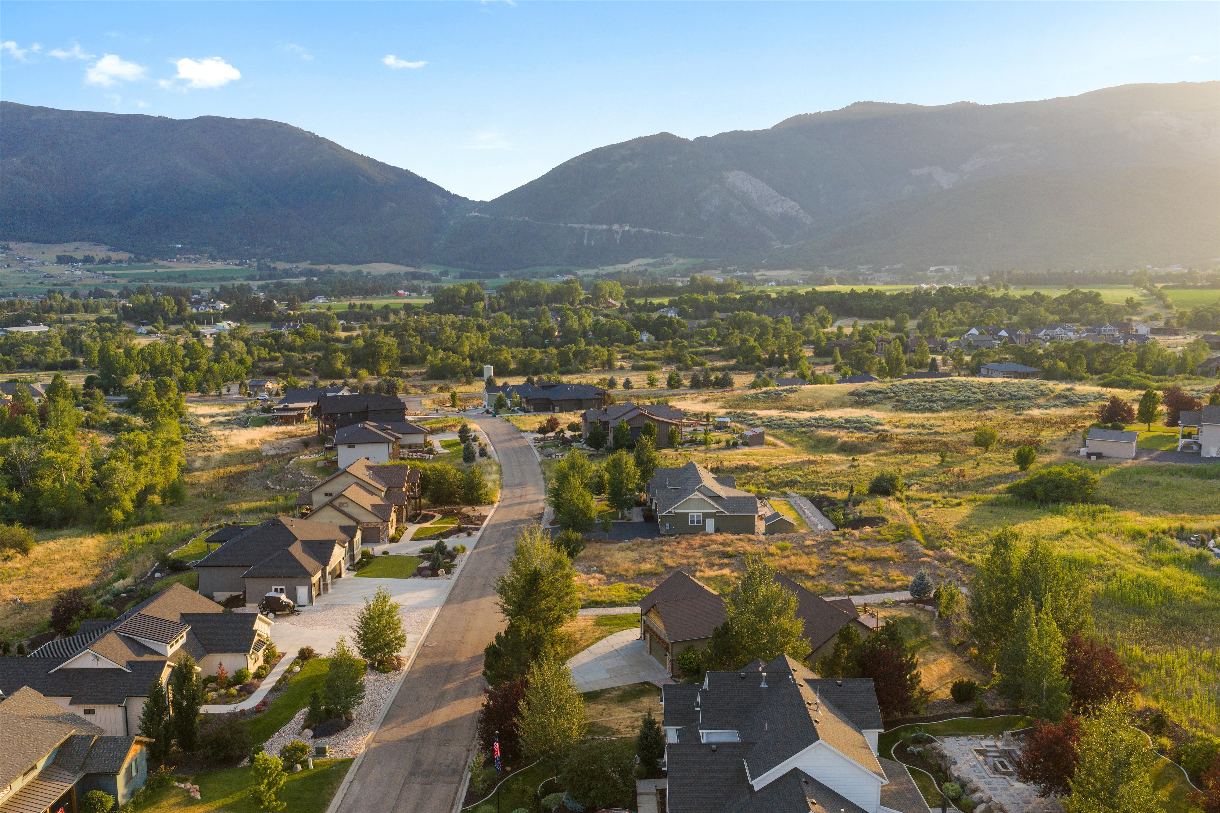 Residential street with surrounding properties nestled within a valley landscape