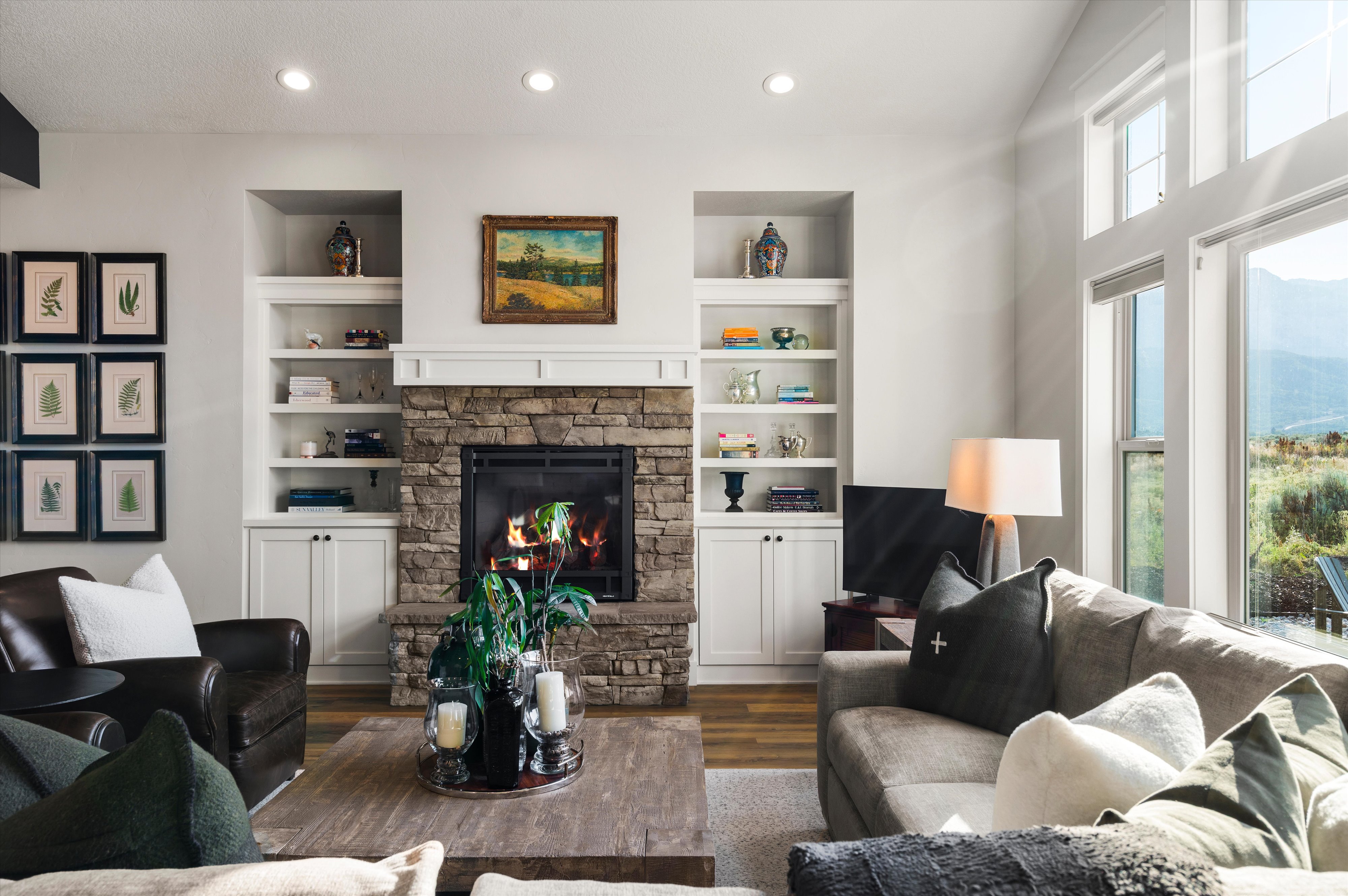 Living room with a stone fireplace featuring a dark metal firebox