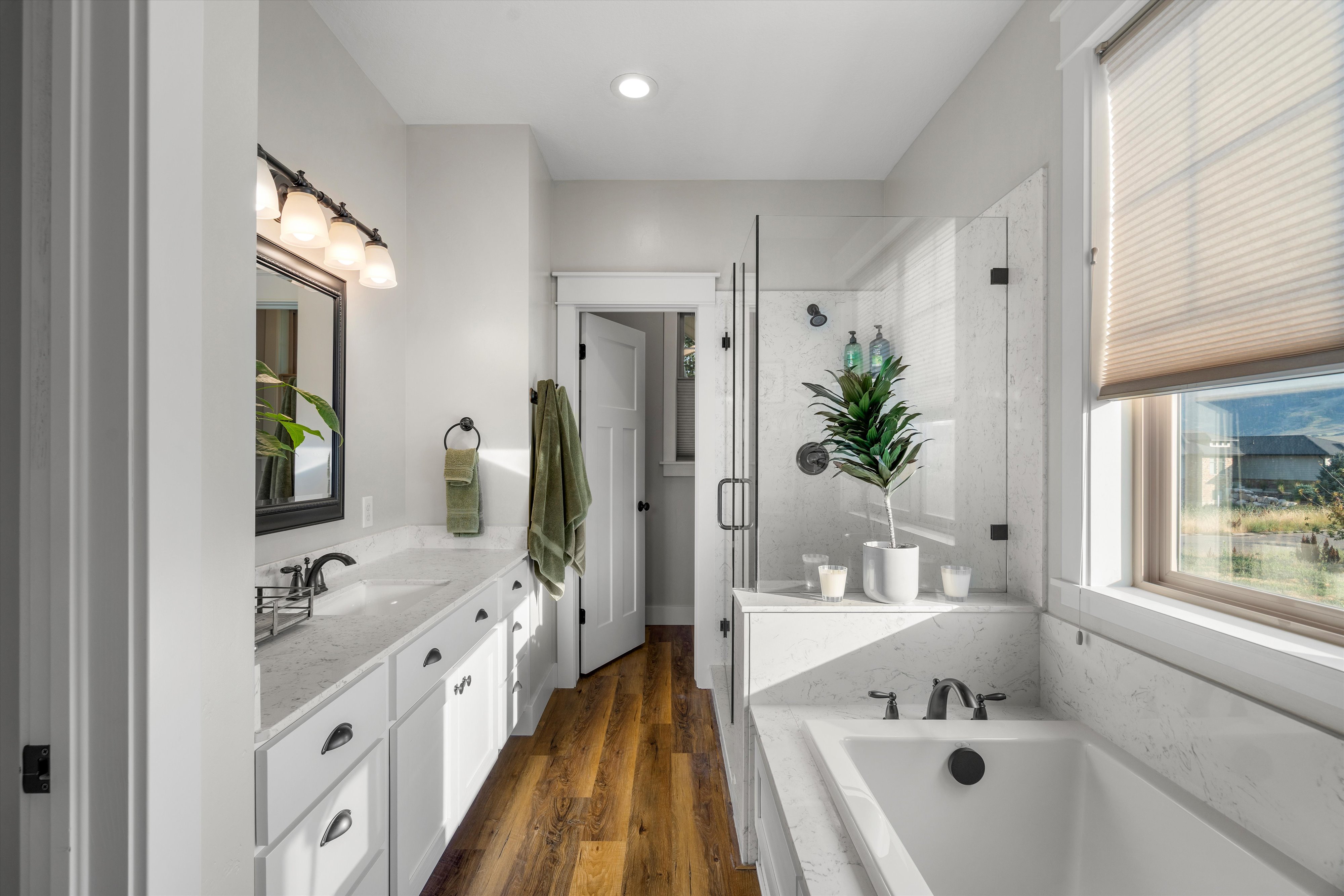 Modern bathroom featuring a dual vanity with white cabinetry and light-toned countertops